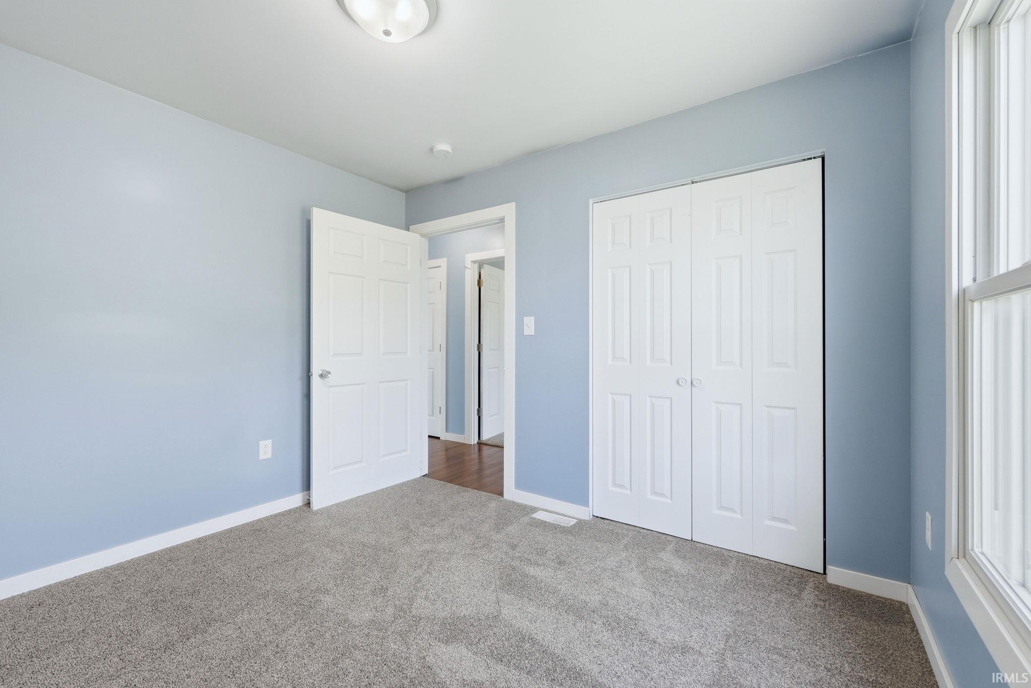 Room featuring light blue walls and gray carpet flooring