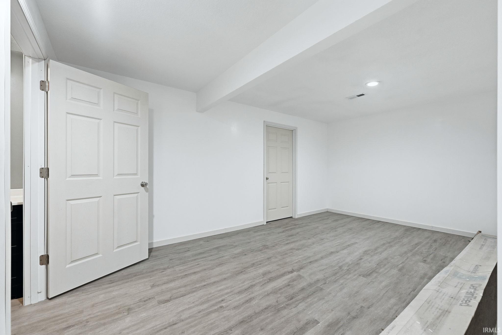 Bright interior space featuring light wood-finish flooring, white walls, and a recessed ceiling light