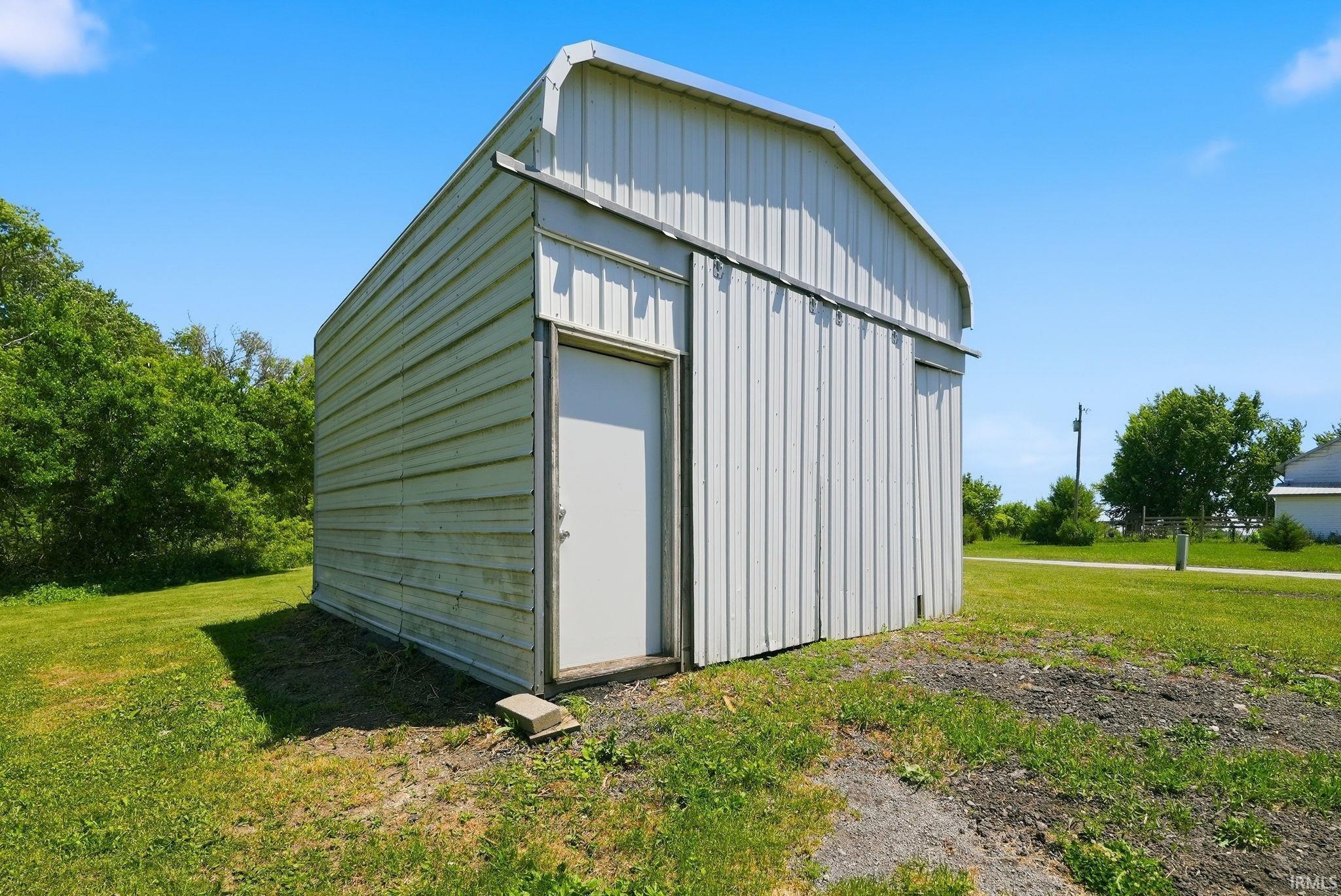 Metal utility building with a single entry door and a sliding barn door system