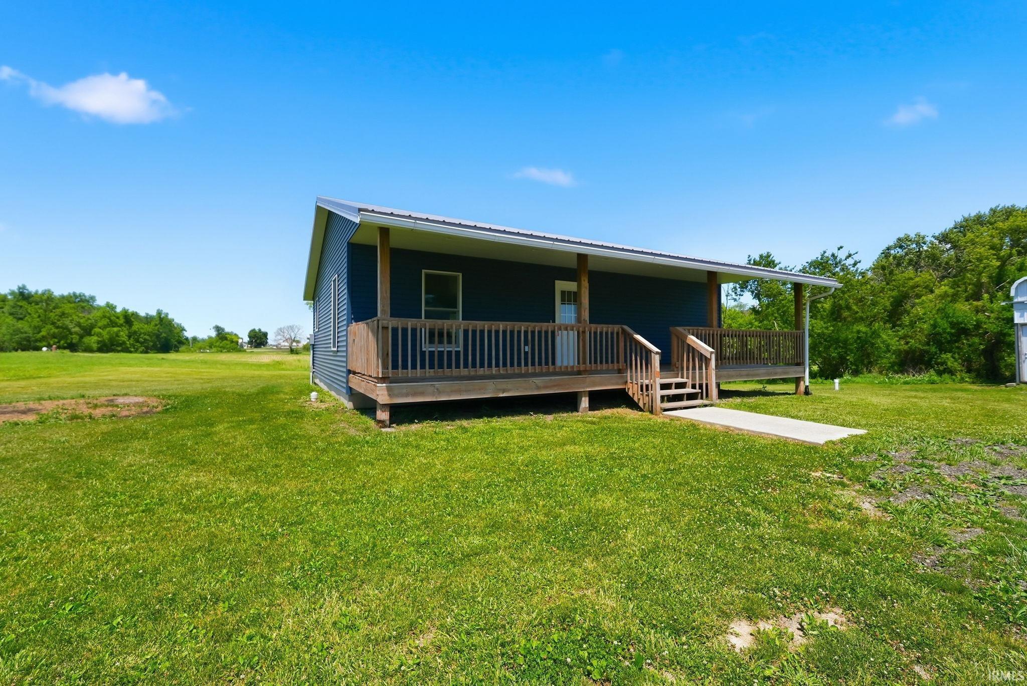 Single-story residence featuring a blue siding exterior and a front porch with natural wood railings