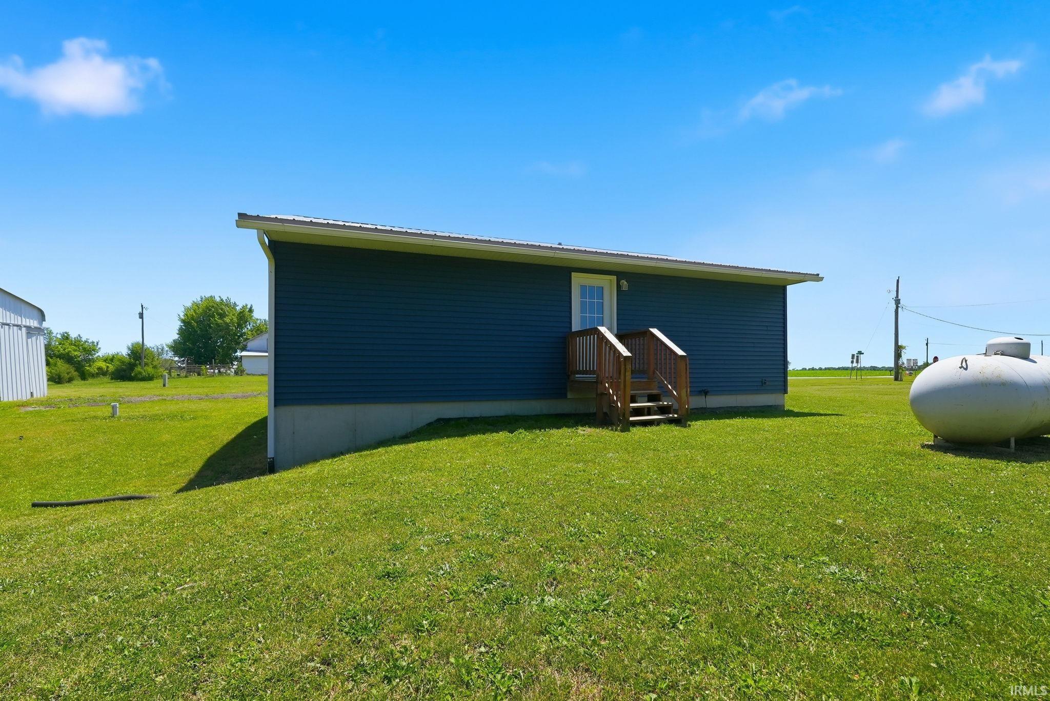 Dark blue horizontal siding exterior with a white entry door and a wood staircase