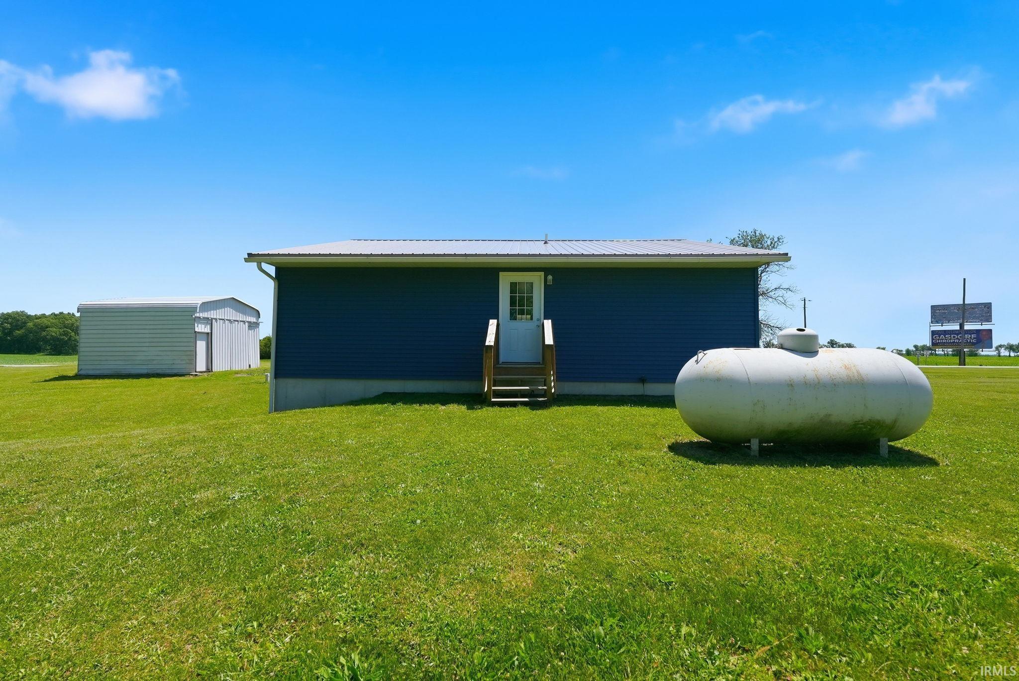 Blue siding exterior with a light gray metal roof