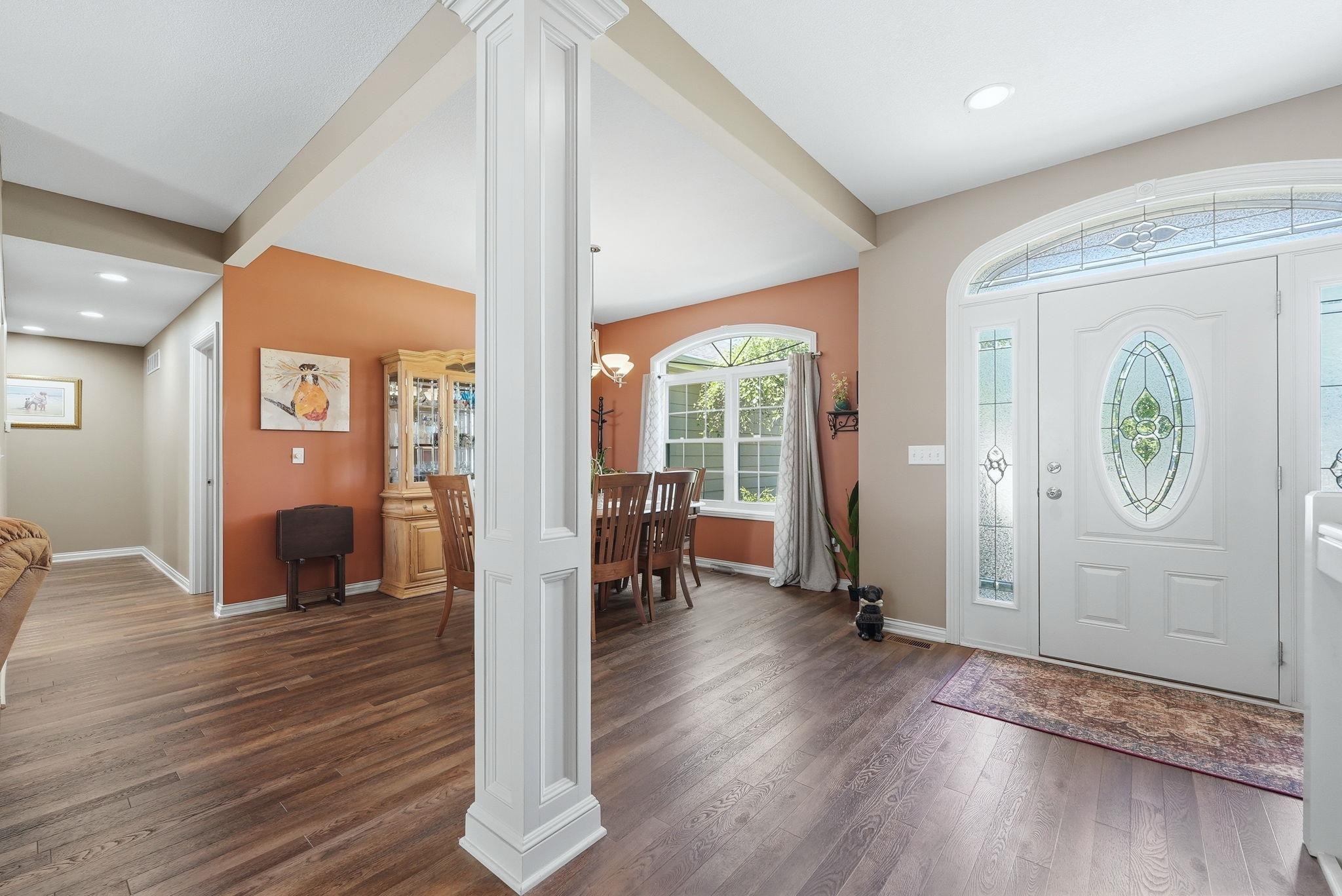 Entryway featuring a decorative transom and sidelights, wood-finish flooring, white architectural columns, and recessed lighting