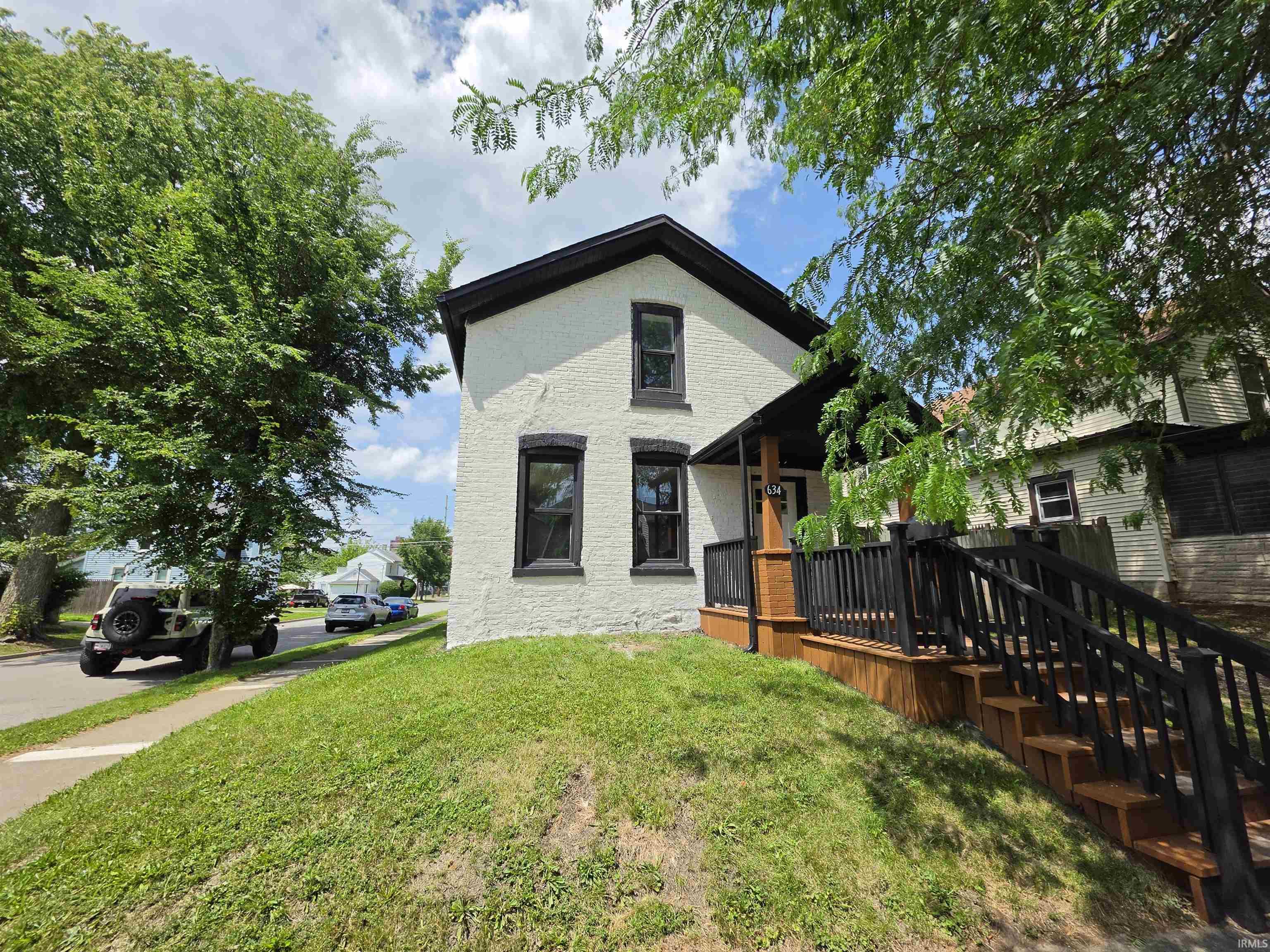 Two-story exterior with white textured siding and contrasting dark trim