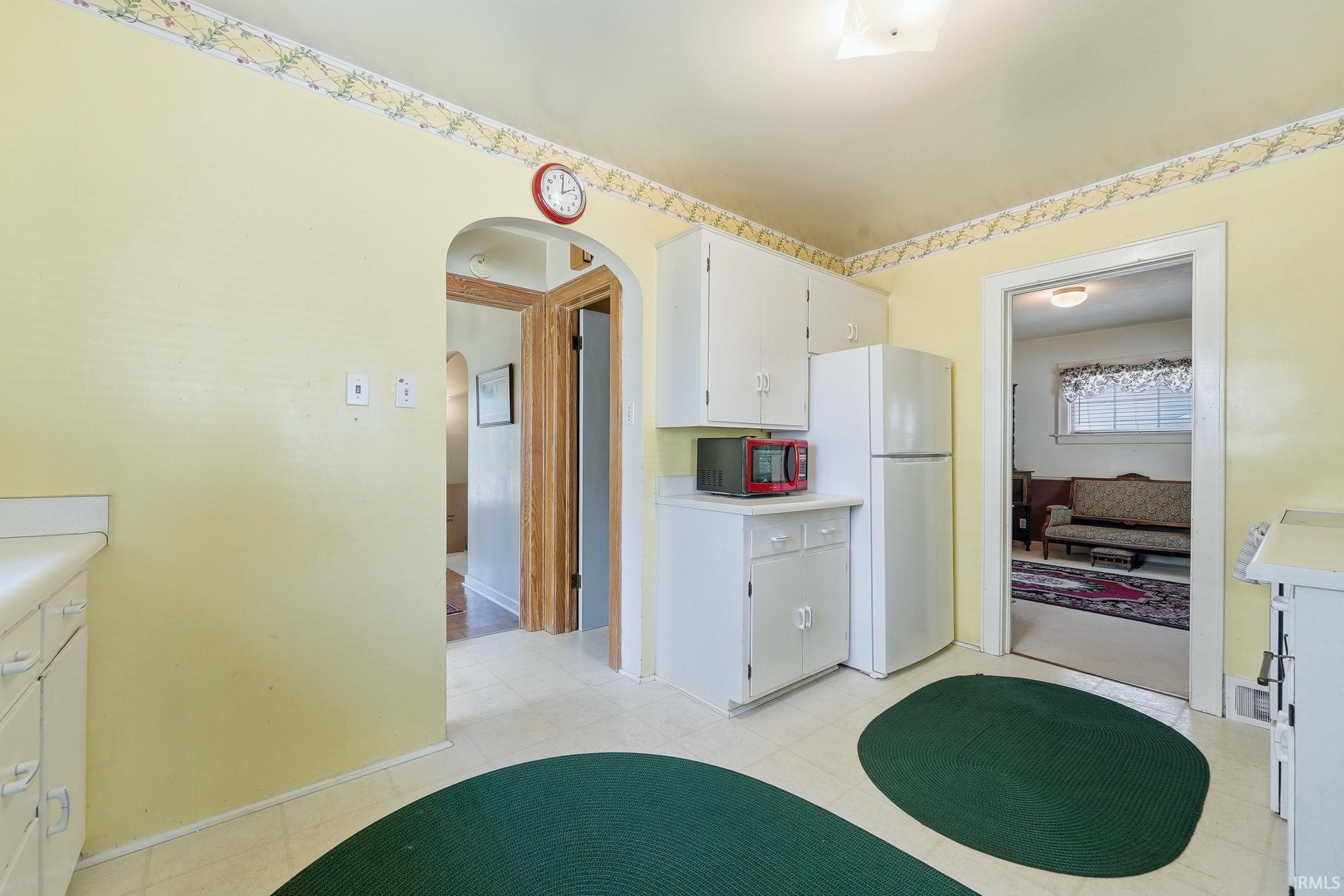 Kitchen featuring white cabinetry, light-colored countertops, and patterned vinyl flooring