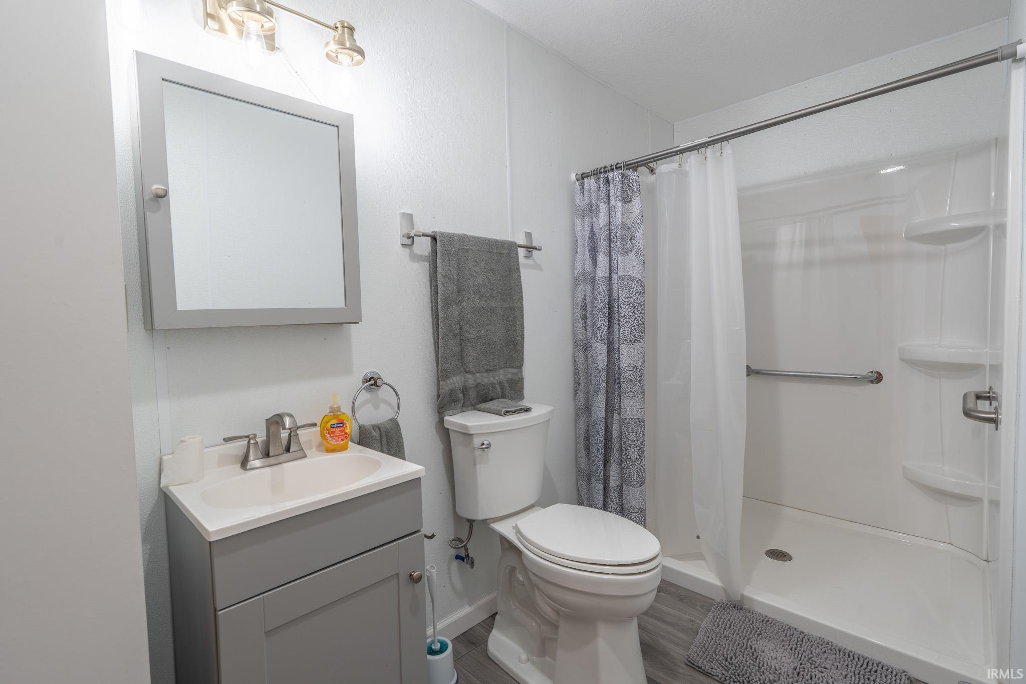 Modern bathroom featuring a single vanity with a gray cabinet and integrated sink