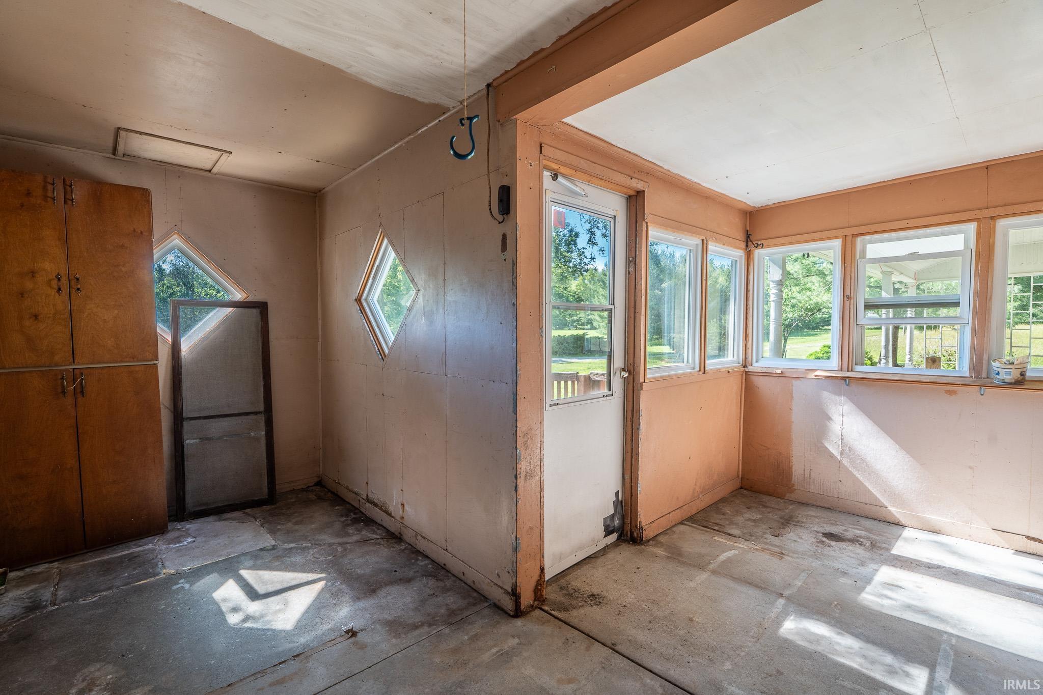 Enclosed porch featuring multiple windows, a paneled door, and two diamond-shaped accent windows