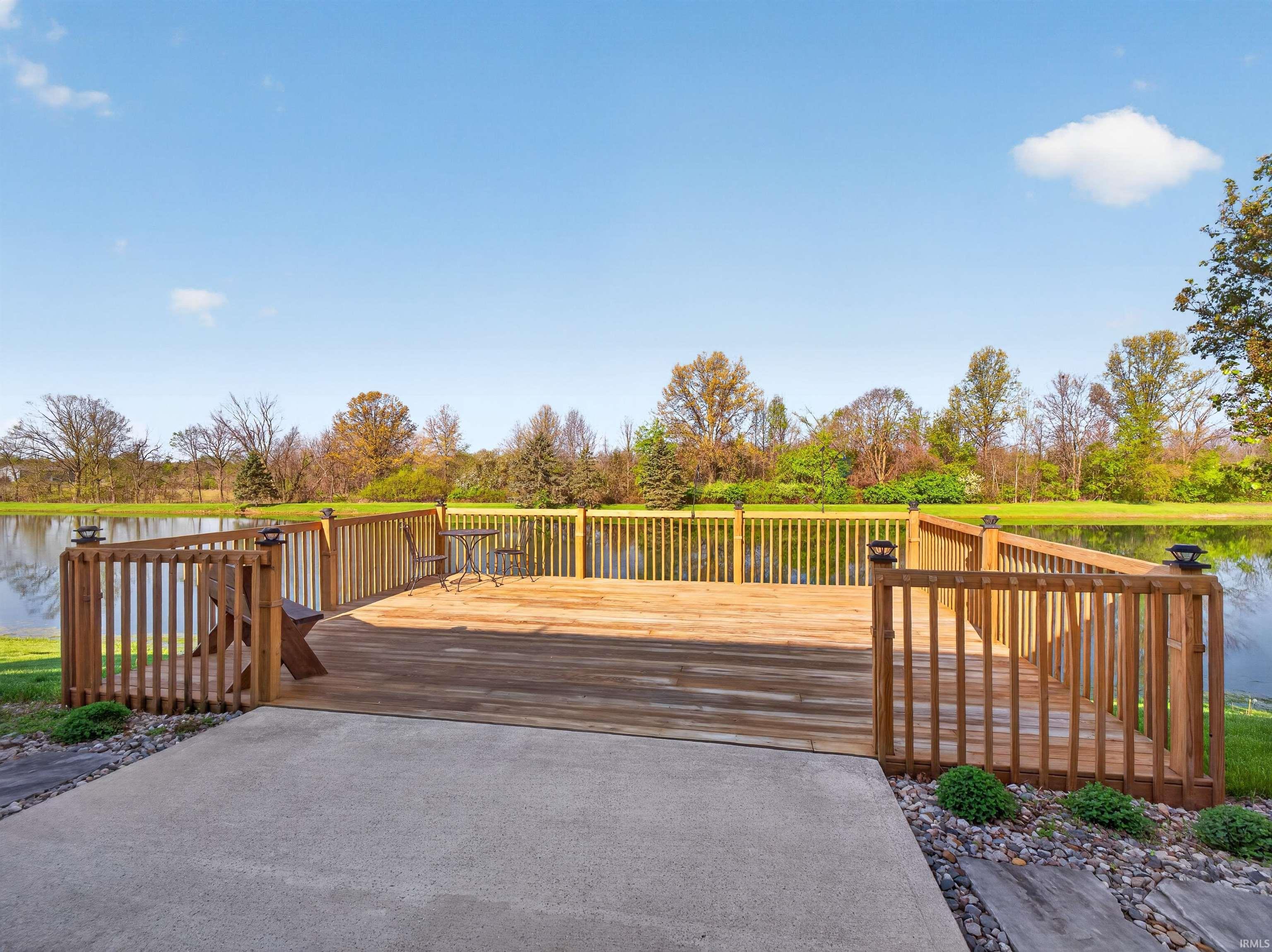 22 X 17 Expansive wood deck with full railing and integrated post cap lighting SOLAR, protrudes to water edge. 12X10 CONCRETE patio additional space