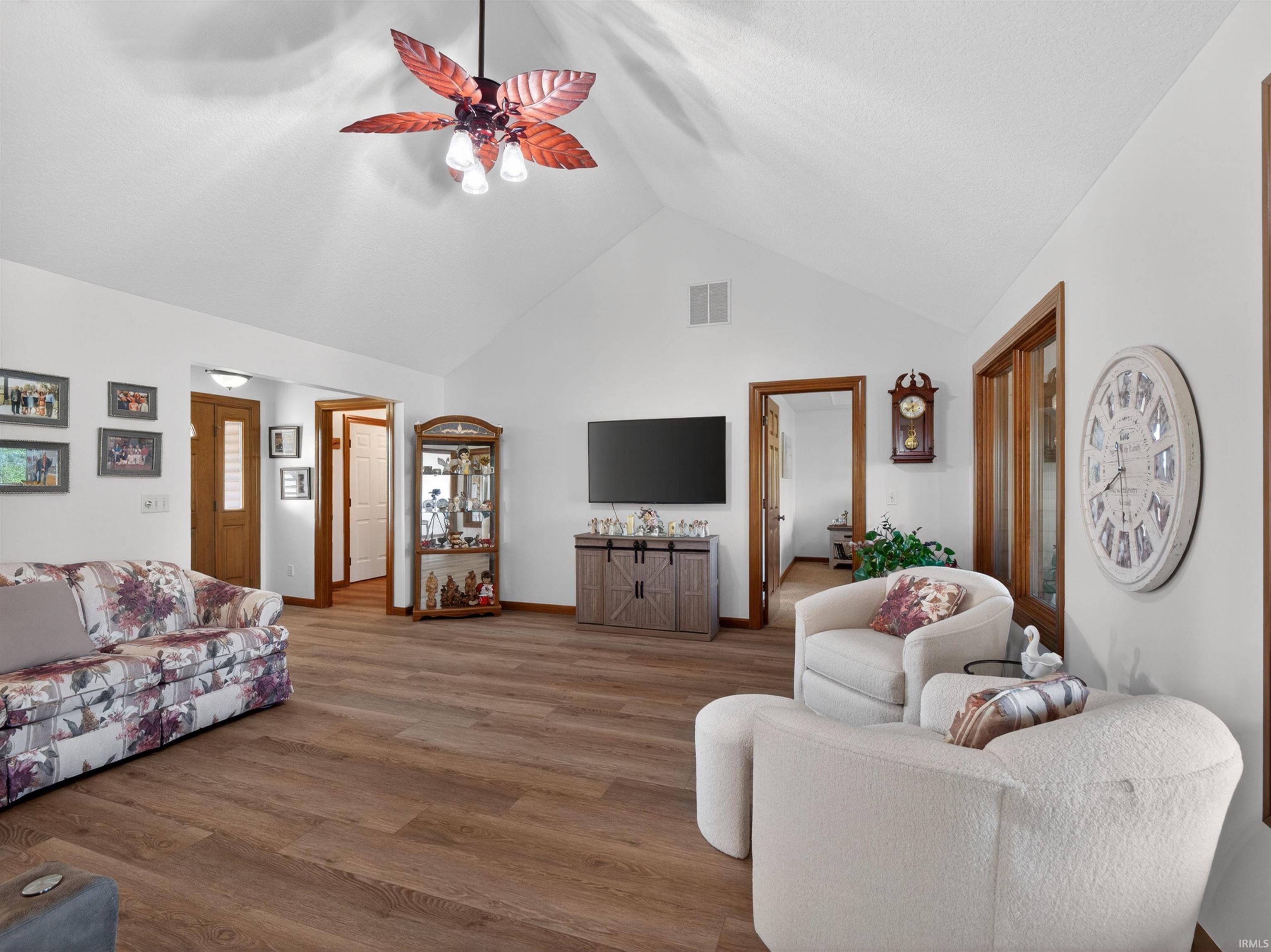 Vaulted ceilings emphasize the spaciousness of this living area, featuring NEW flooring and a decorative ceiling fan