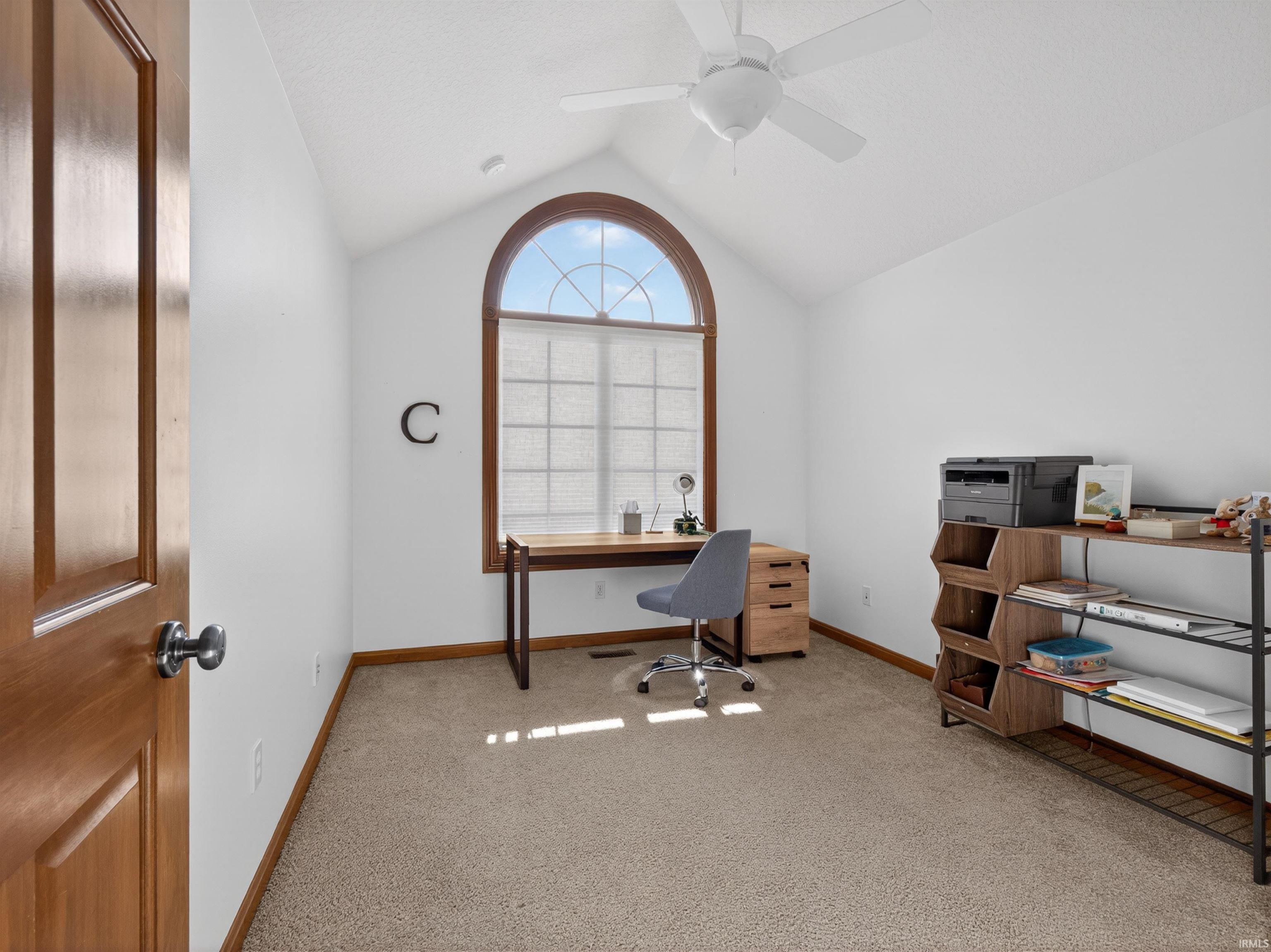 Room featuring a vaulted ceiling and an arched window with CUSTOM BLINDS WALK IN CLOSET