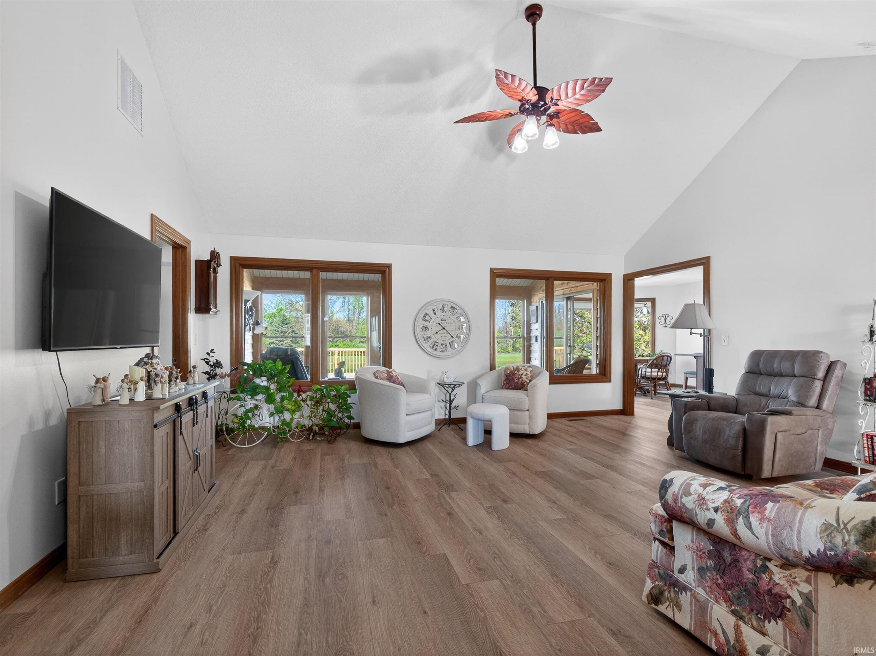 Bright living area with vaulted ceilings and wood-finish flooring