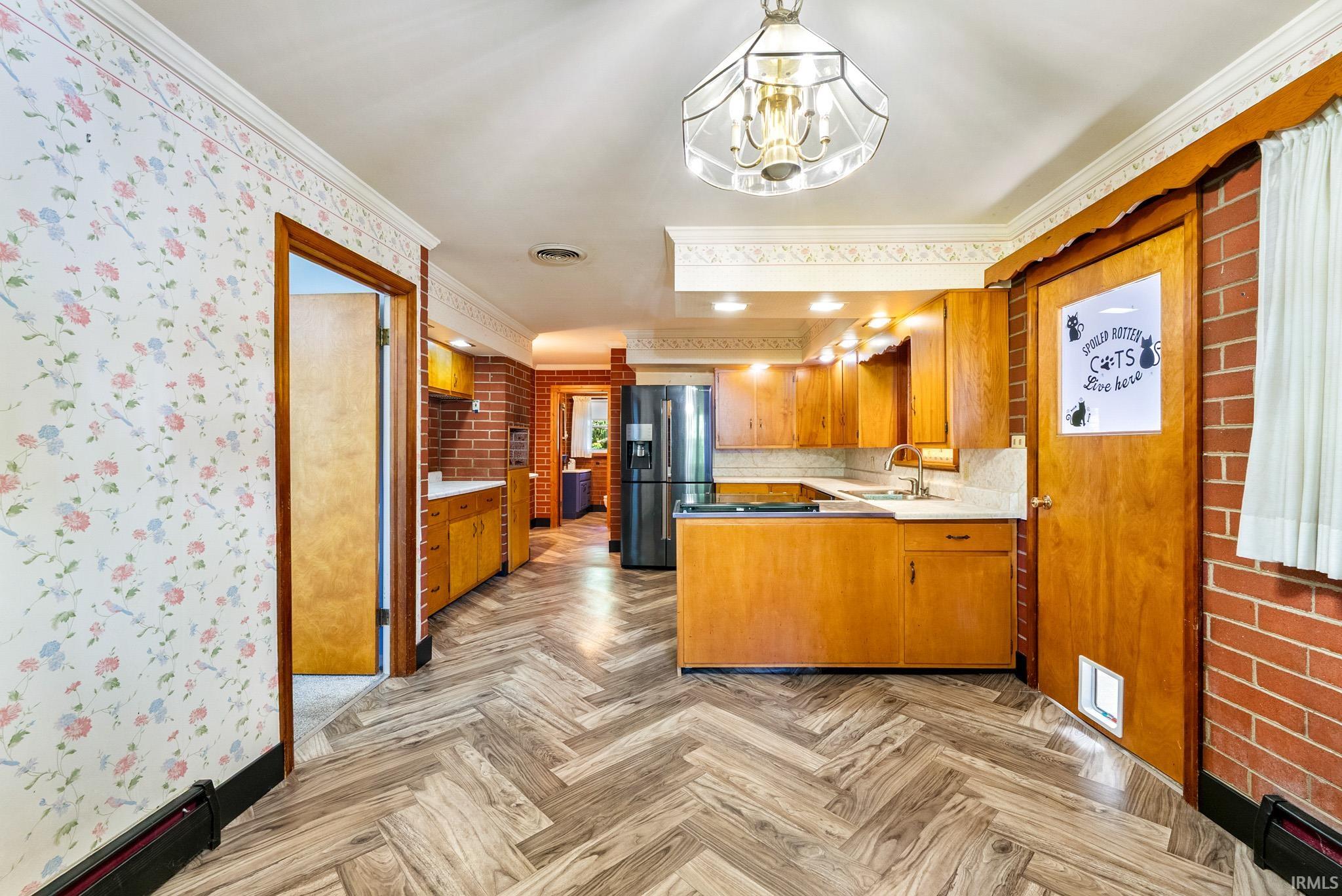 U-shaped kitchen featuring wood cabinetry, light countertops, and a full suite of appliances