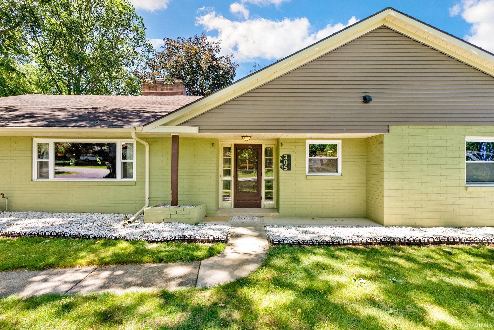 Ranch-style exterior with lime green brick and tan siding accents