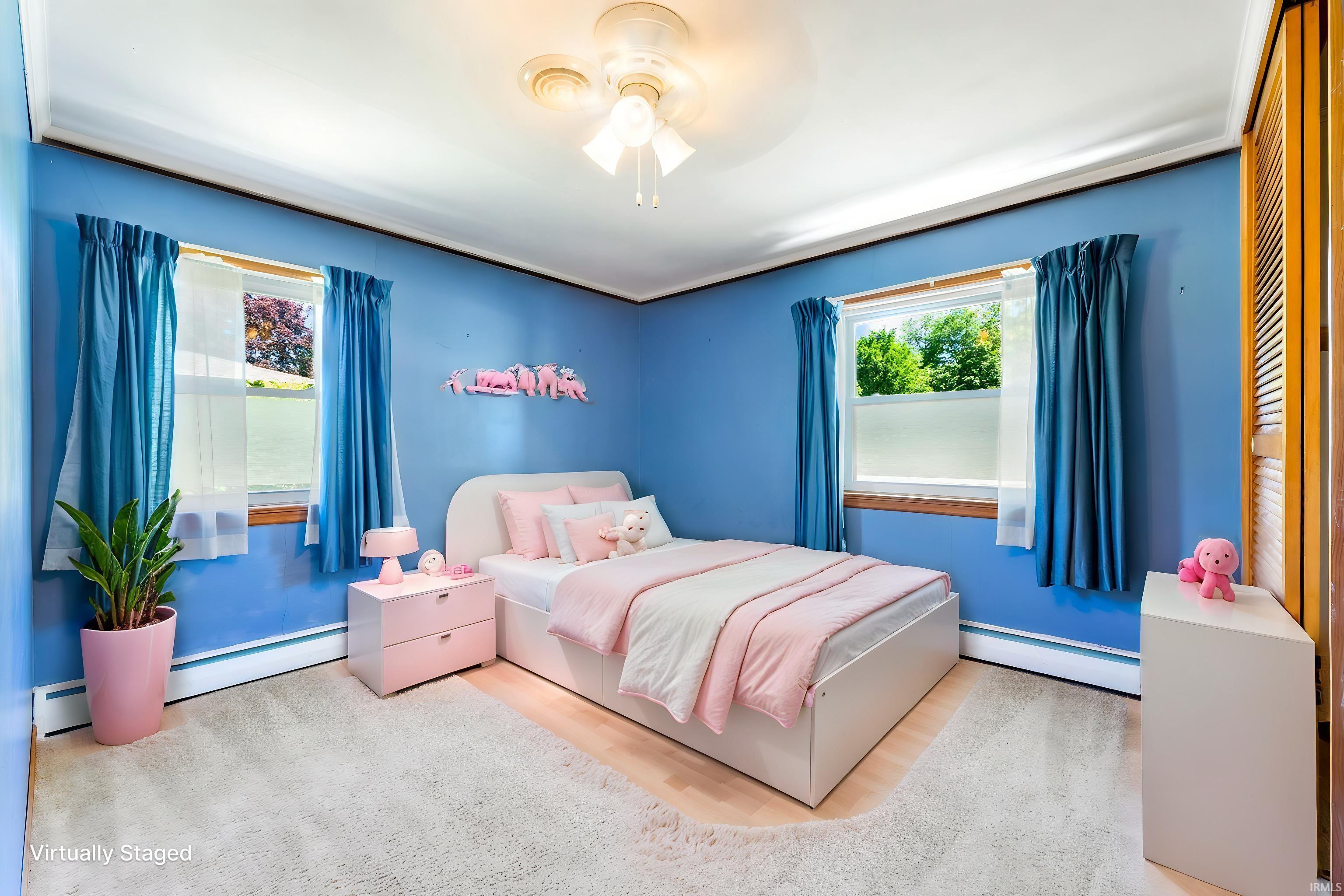 Carpeted room with blue walls, white trim, and a ceiling fan light fixture