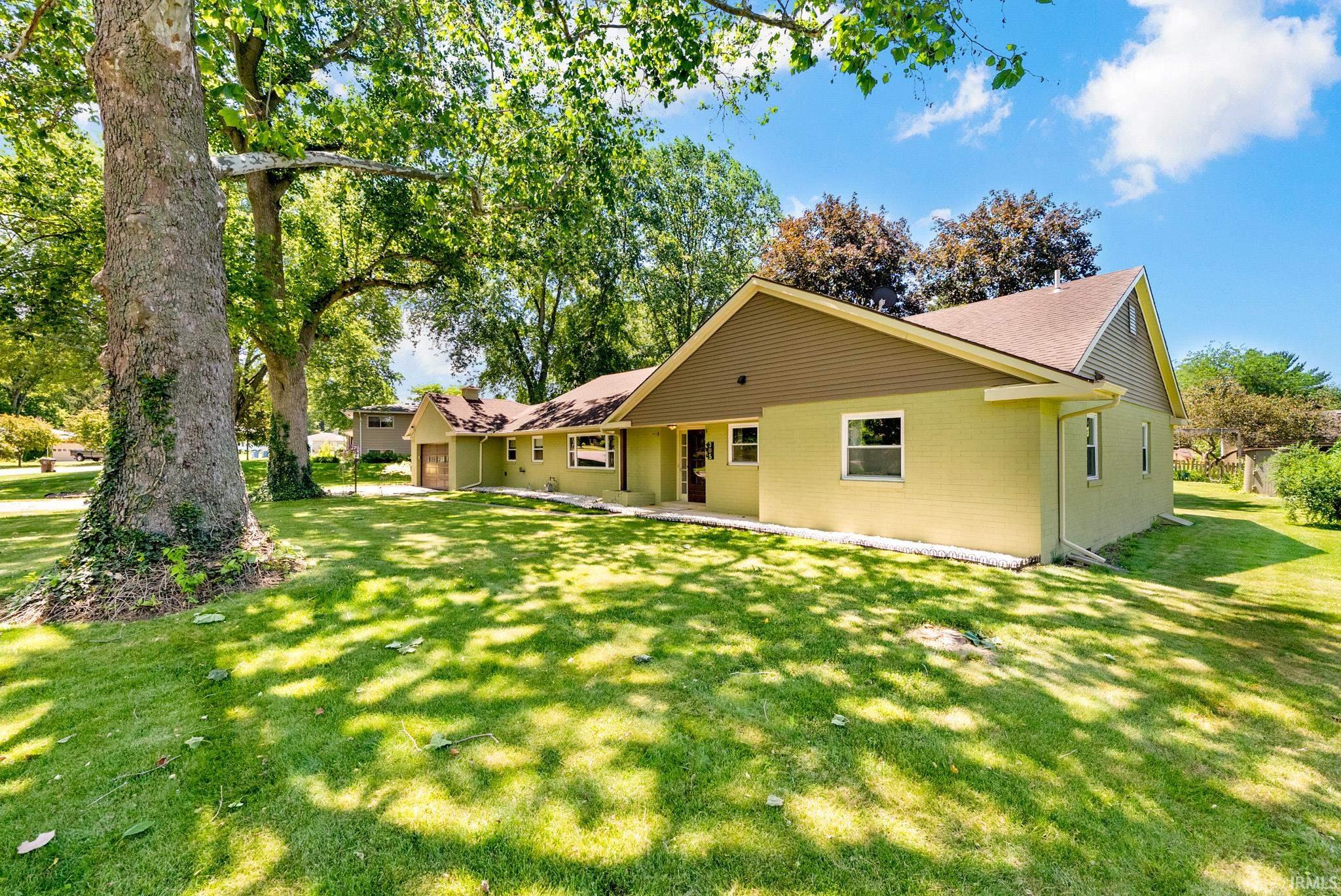 Ranch-style exterior featuring light yellow brick siding and a brown shingle roof