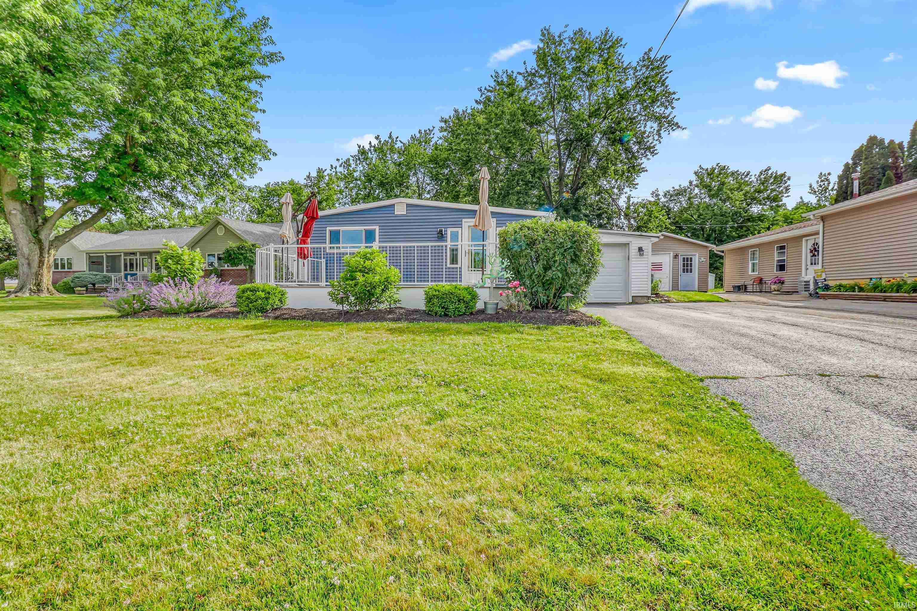 Spacious front yard with mature trees and a manicured lawn