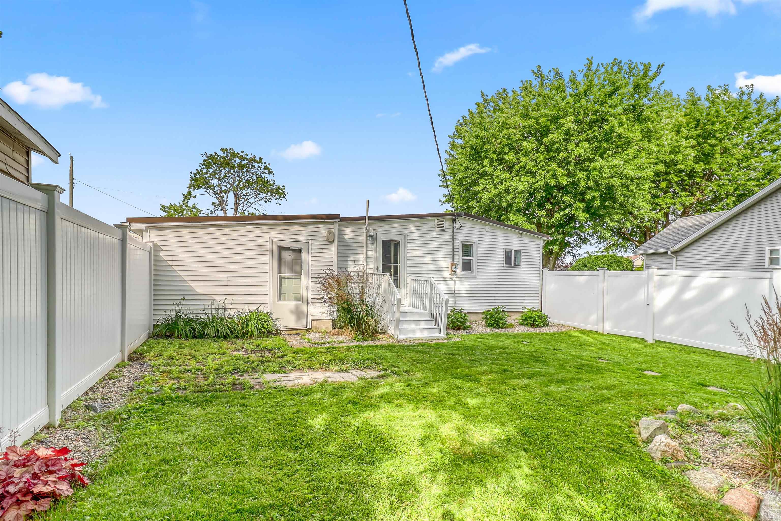 Expansive green lawn with a full vinyl privacy fence