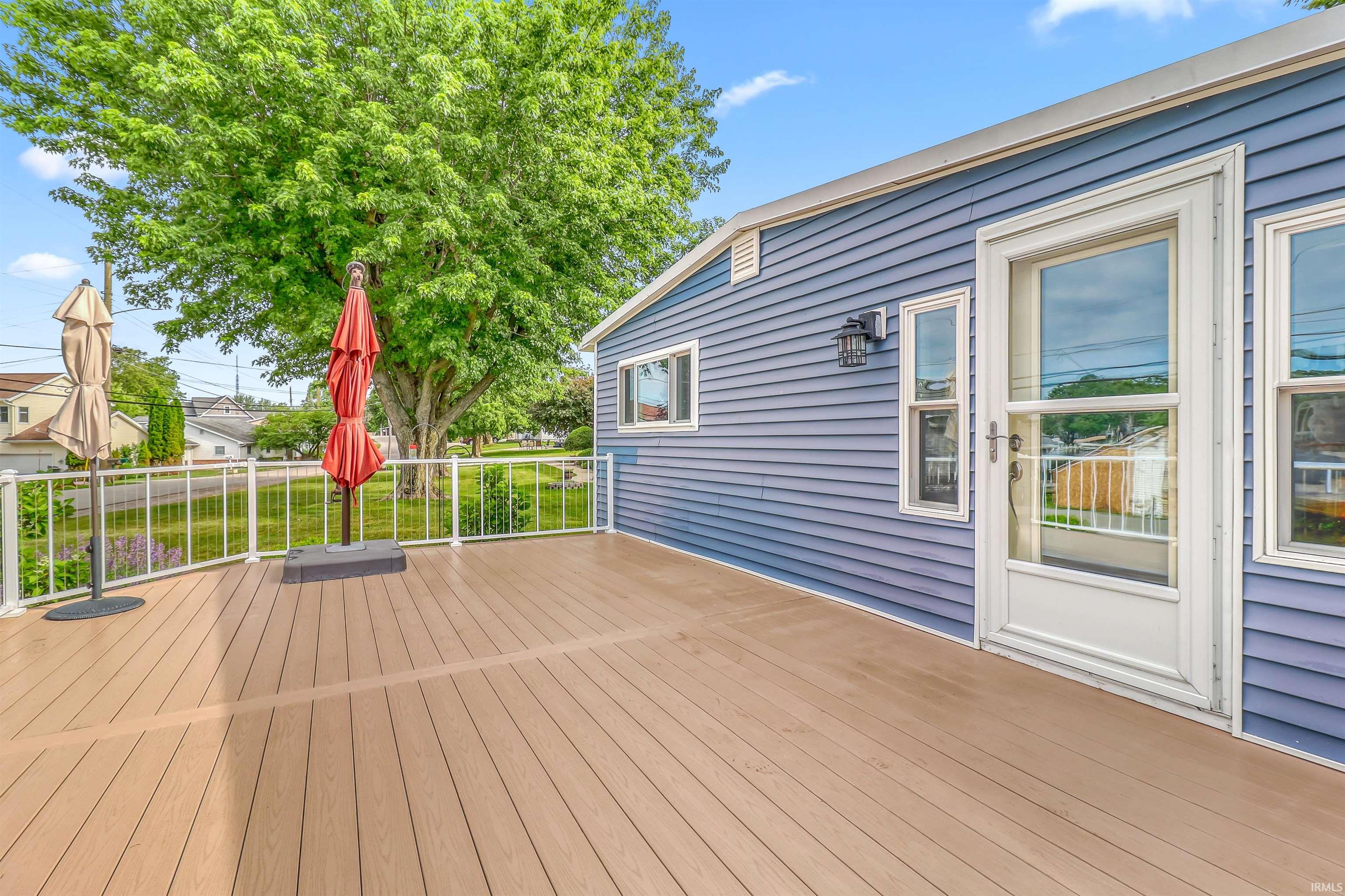 Spacious outdoor deck featuring composite flooring and white railing