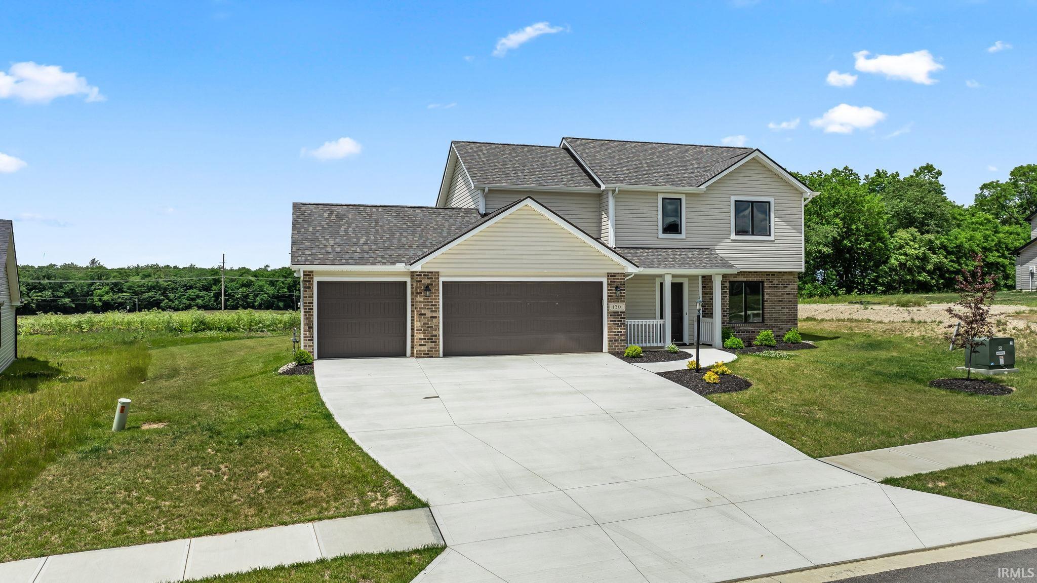 Two-story residence featuring light-colored siding and stone veneer accents