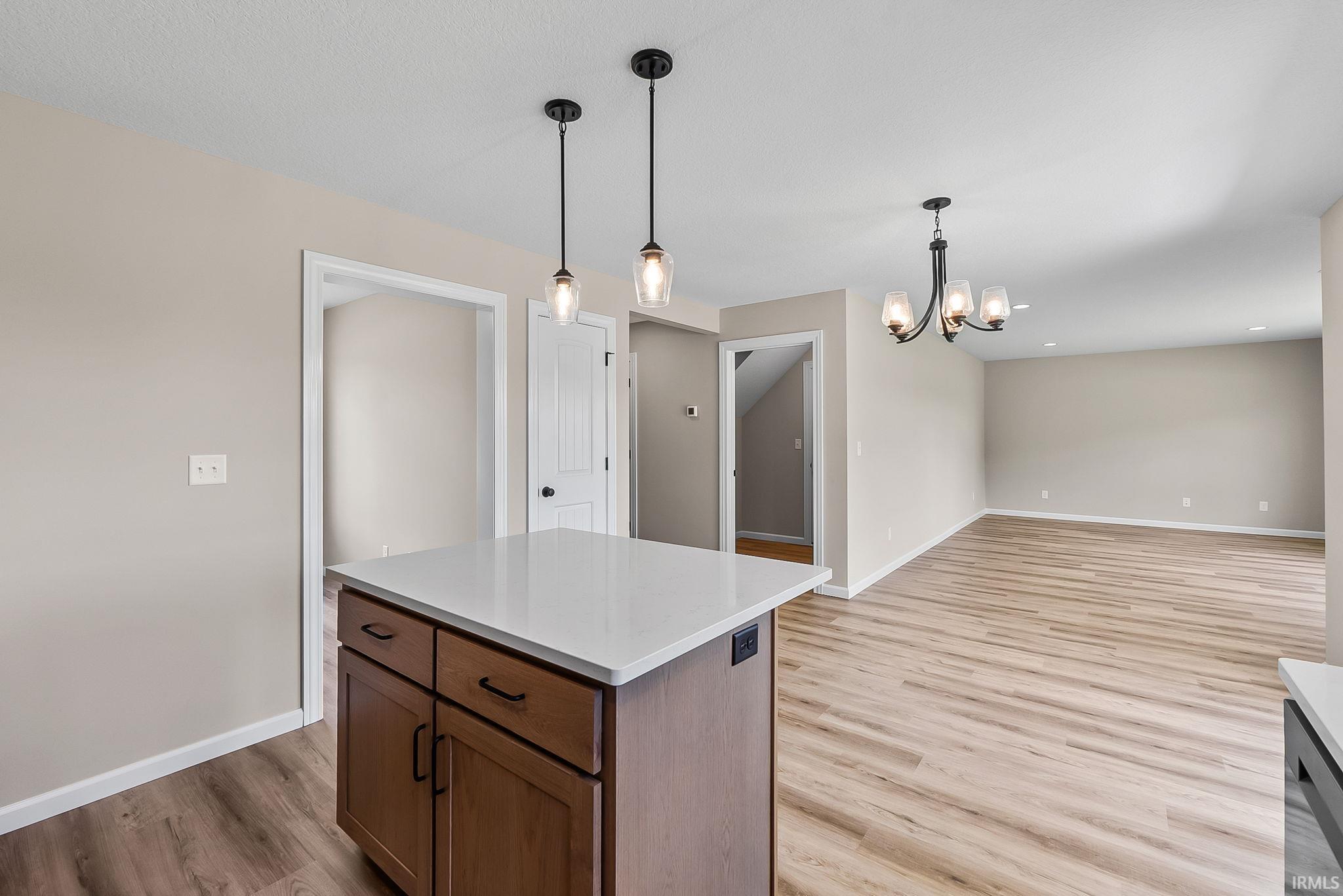 Kitchen island with a white countertop and two suspended pendant lights