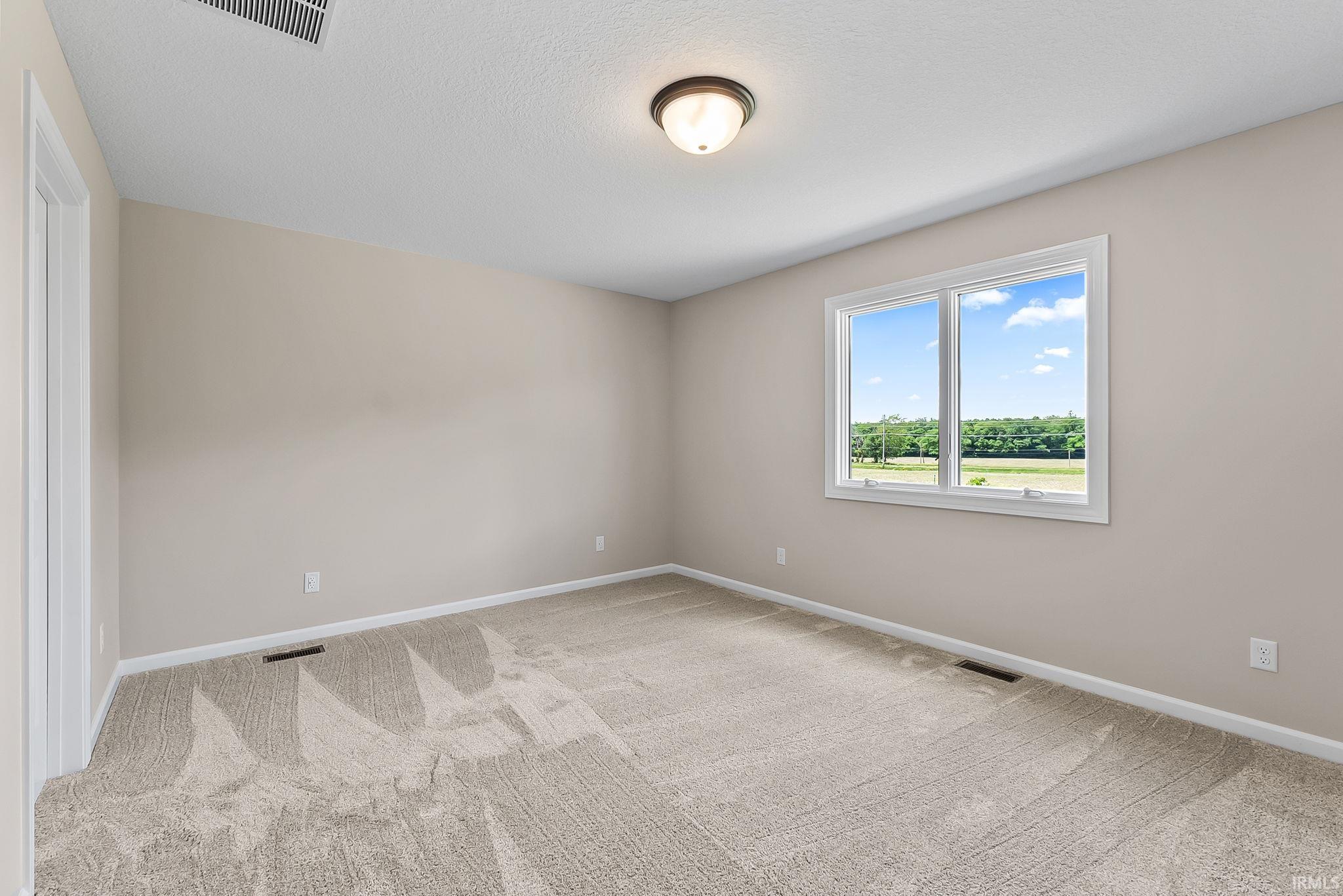 Carpeted room with neutral wall tones and white trim
