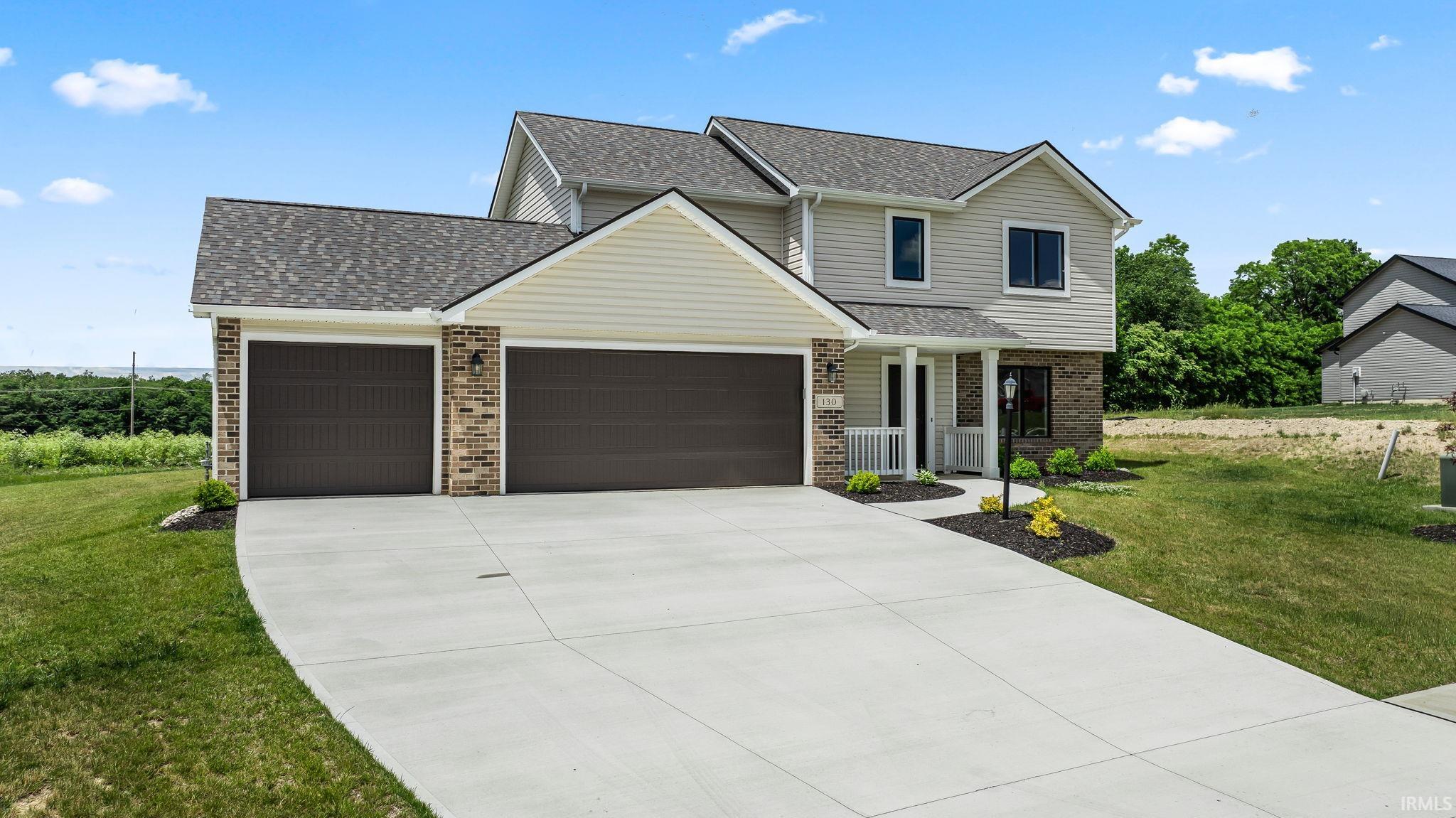 Two-story residence featuring light-toned siding and dark shingle roofing