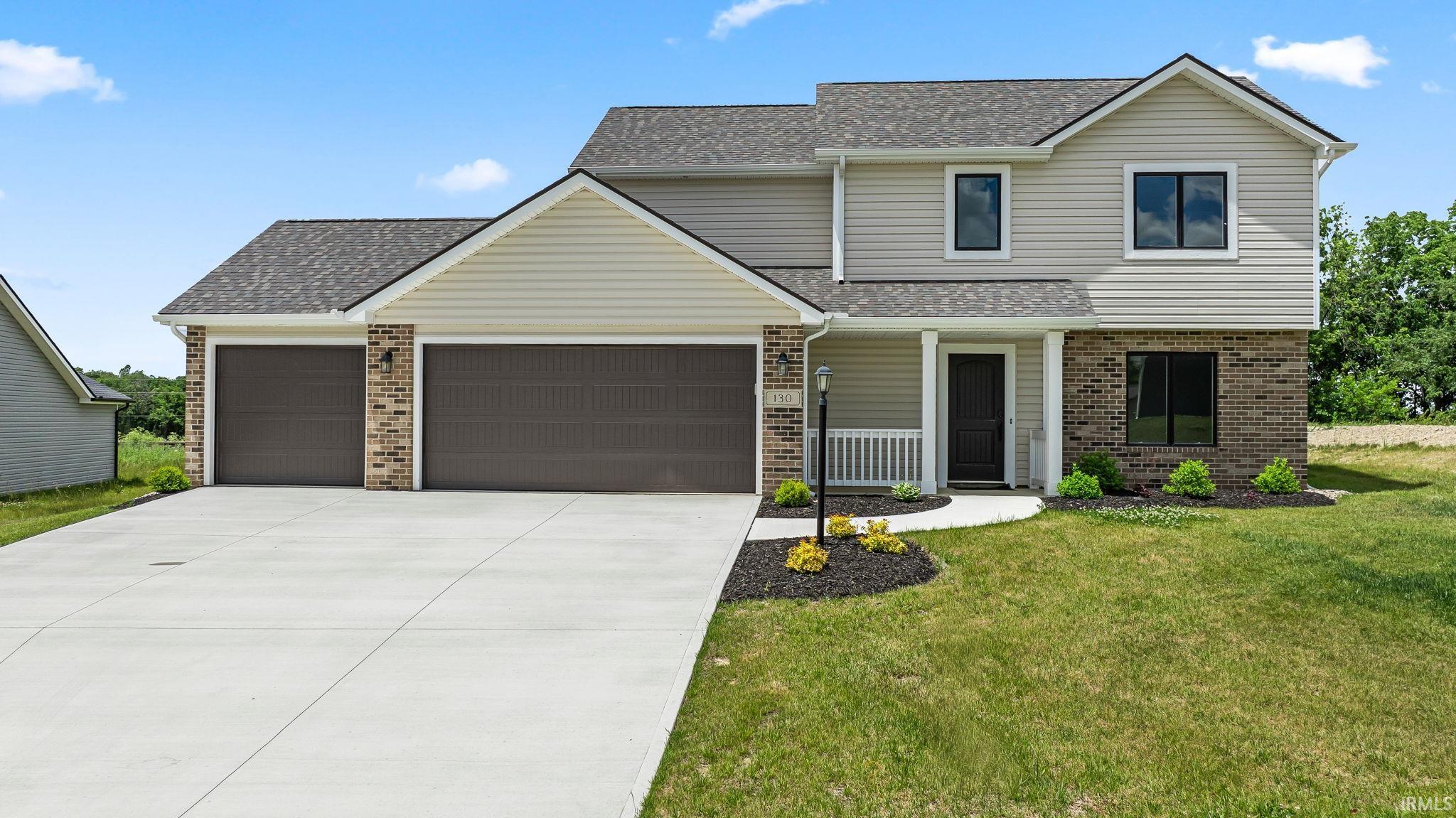 Contemporary home featuring a dual-tone exterior with light siding and brick accents