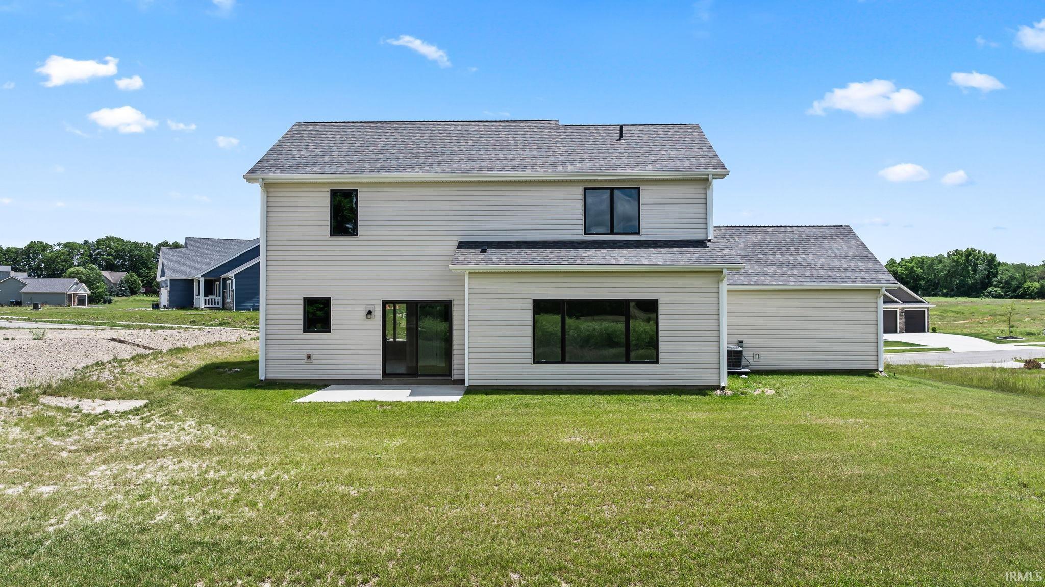 Two-story exterior with light-toned siding, a dark shingle roof, and black-framed windows