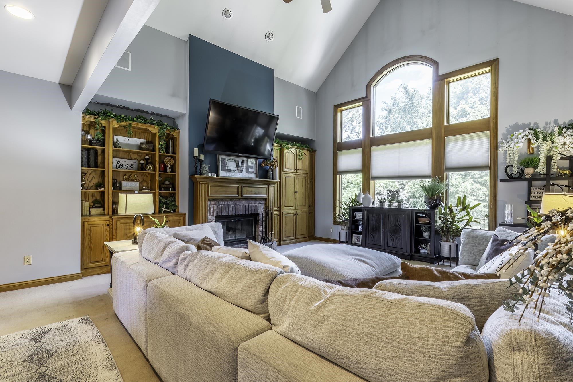 Spacious living area featuring a vaulted ceiling and exposed beams