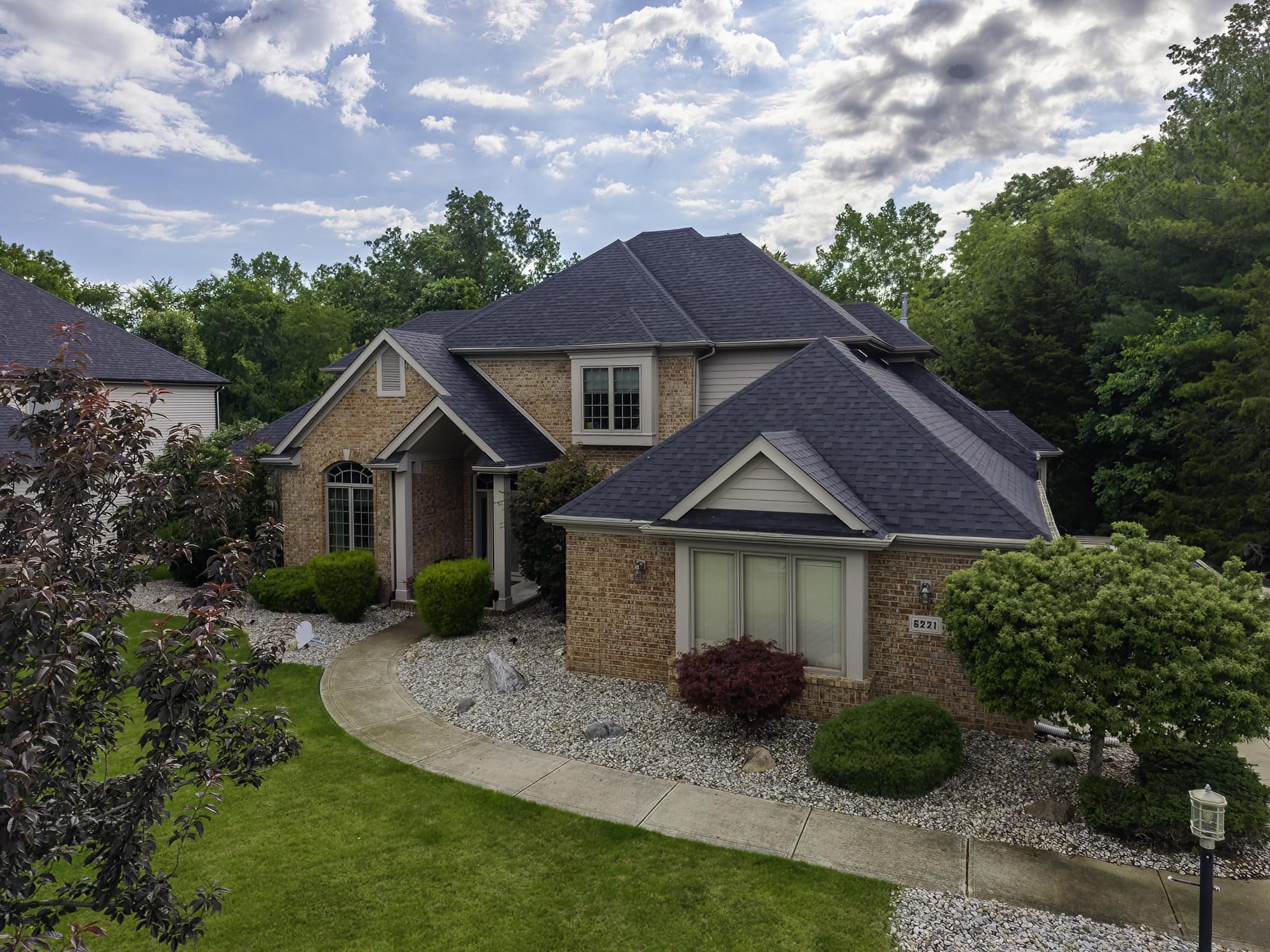 Brick and siding exterior with dark shingle roofing