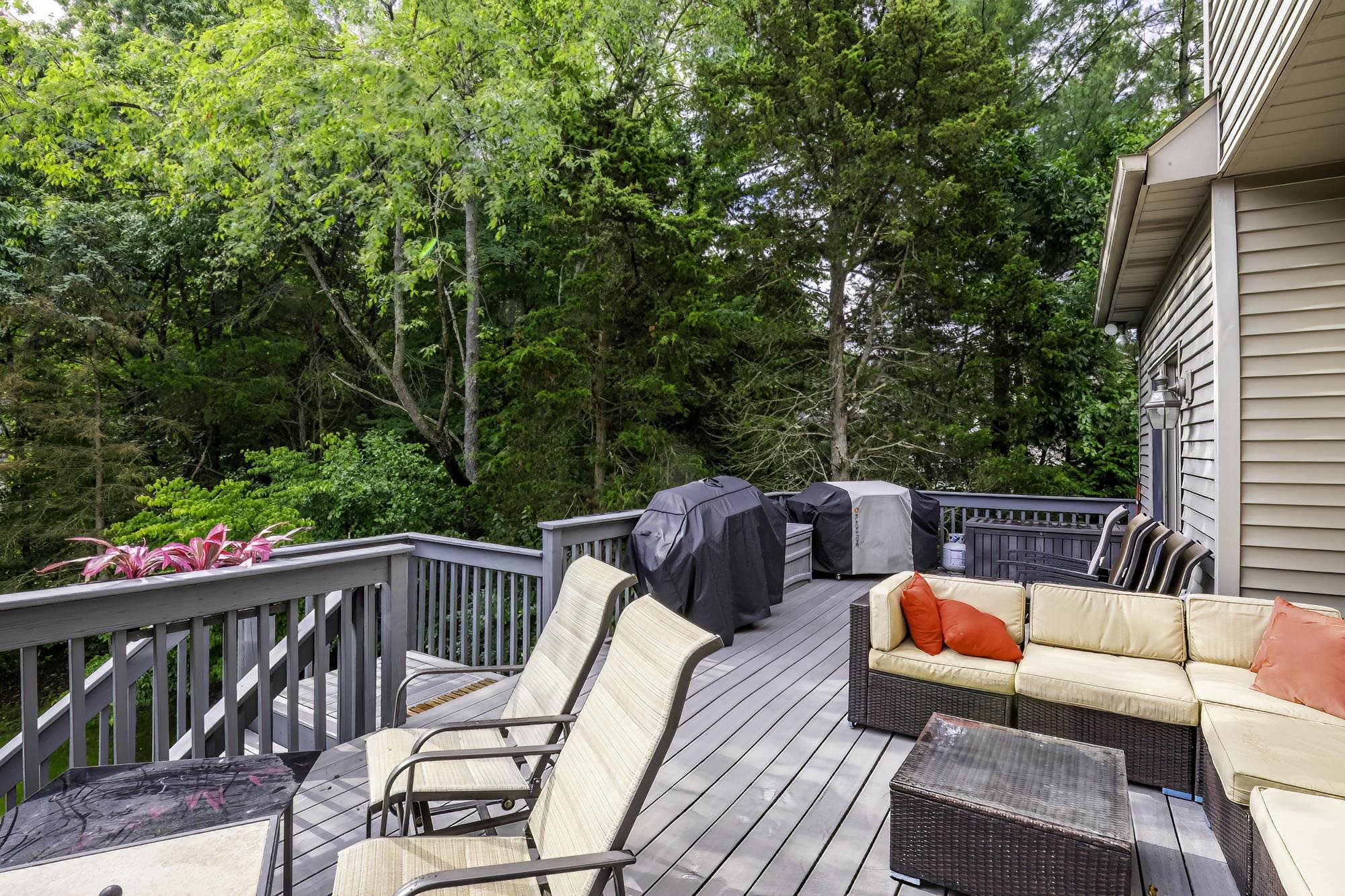 Expansive grey wood-finish deck with full railing system