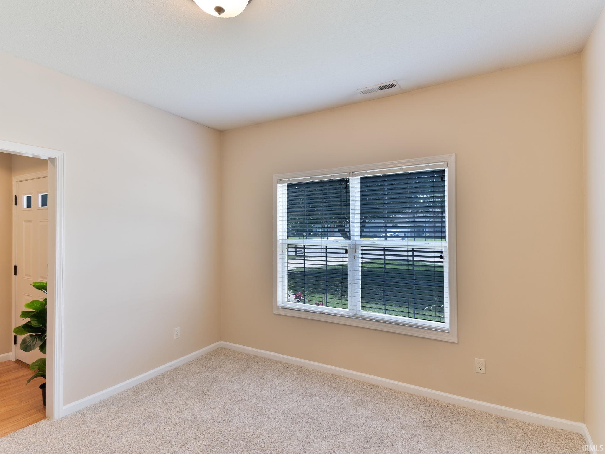 Room featuring a window with blinds, neutral wall paint, and light-colored floors