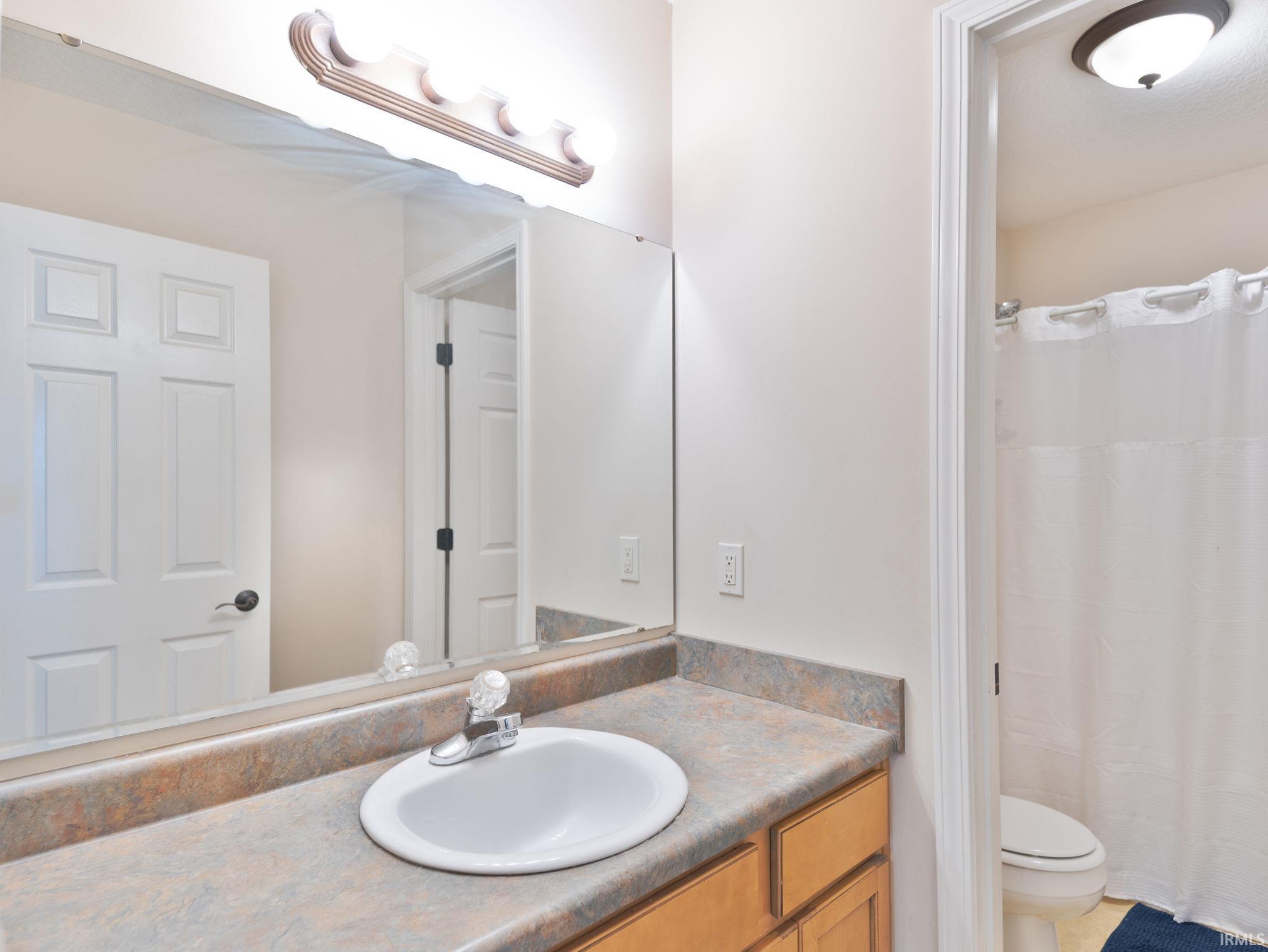 Bathroom vanity with an integrated sink, laminate countertop, and wood-finish cabinetry