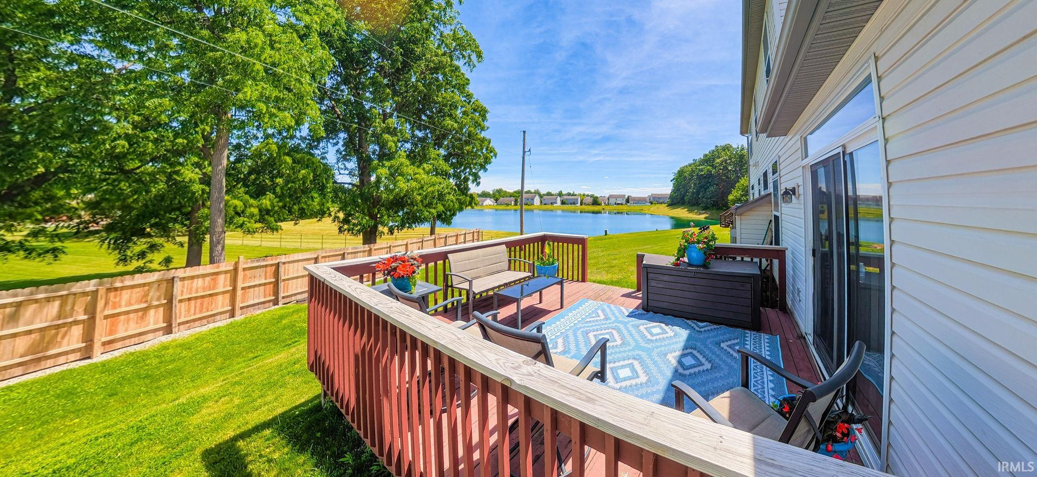 Private rear deck with wood railing, offering a waterfront panorama