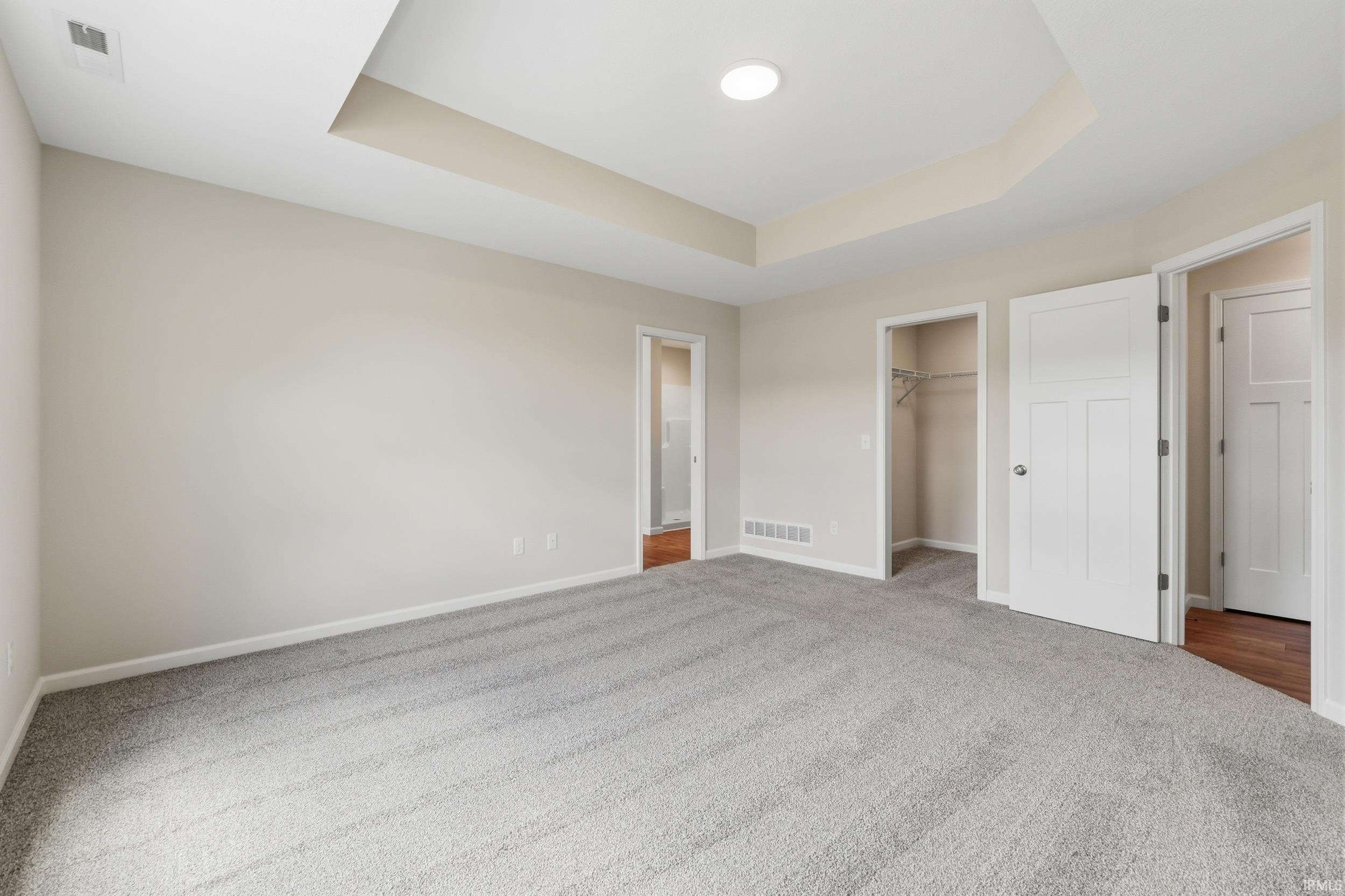 Spacious room featuring light gray carpet flooring and neutral wall tones
