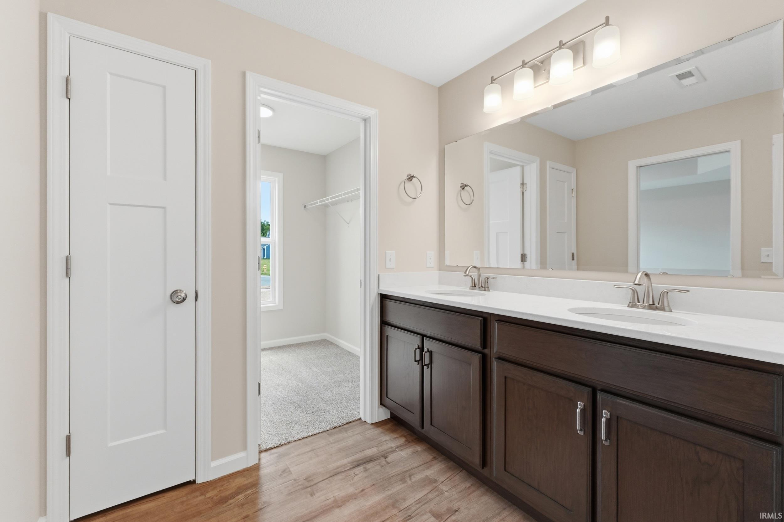 Dual vanity with white countertops and dark wood cabinetry