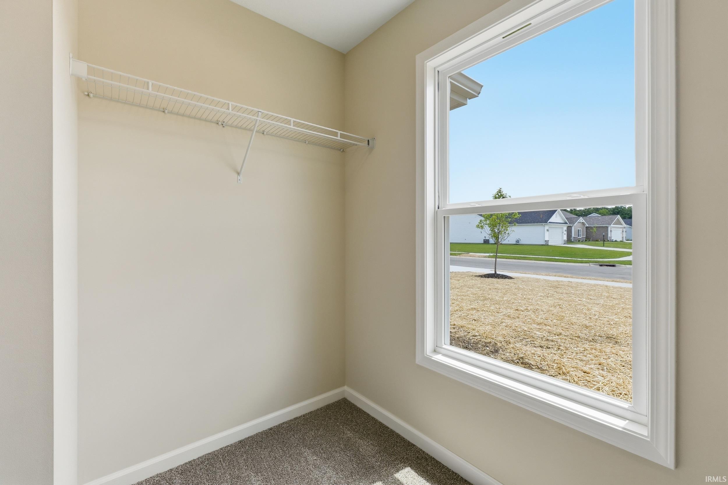 Neutral-toned interior with a single-hung window featuring white trim