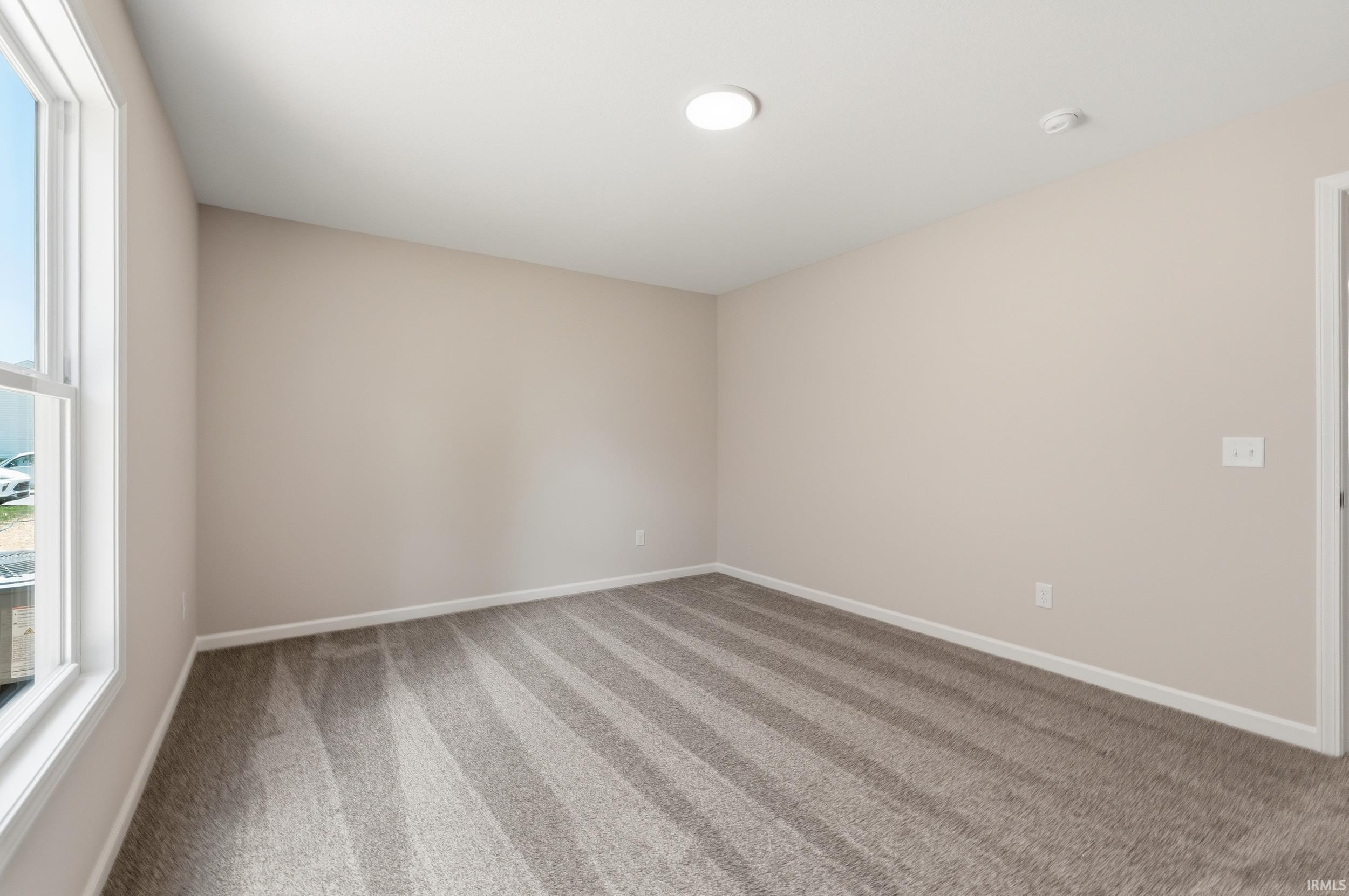 Room featuring beige wall paint, white trim, and a window with white framing
