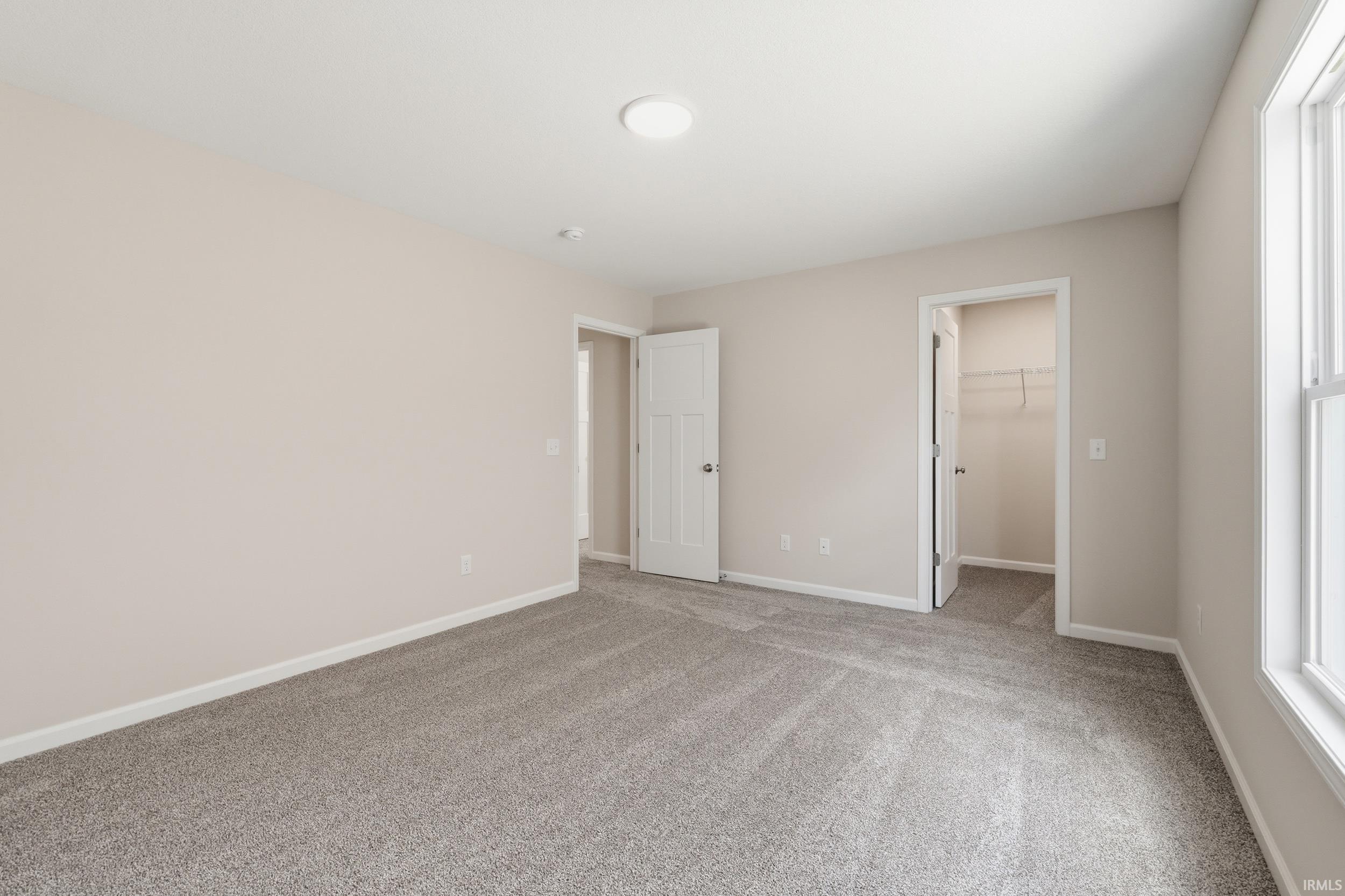 Carpeted interior space with light neutral wall paint