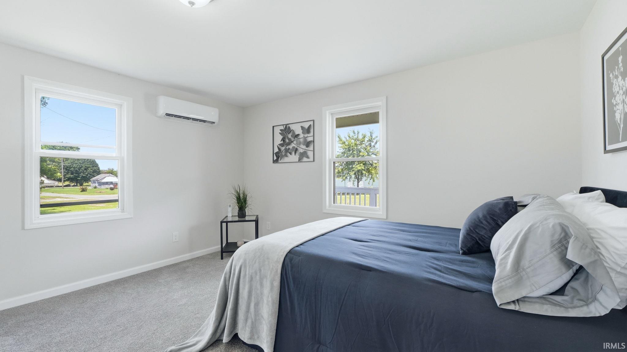 Bright interior space featuring light gray carpeting and white walls