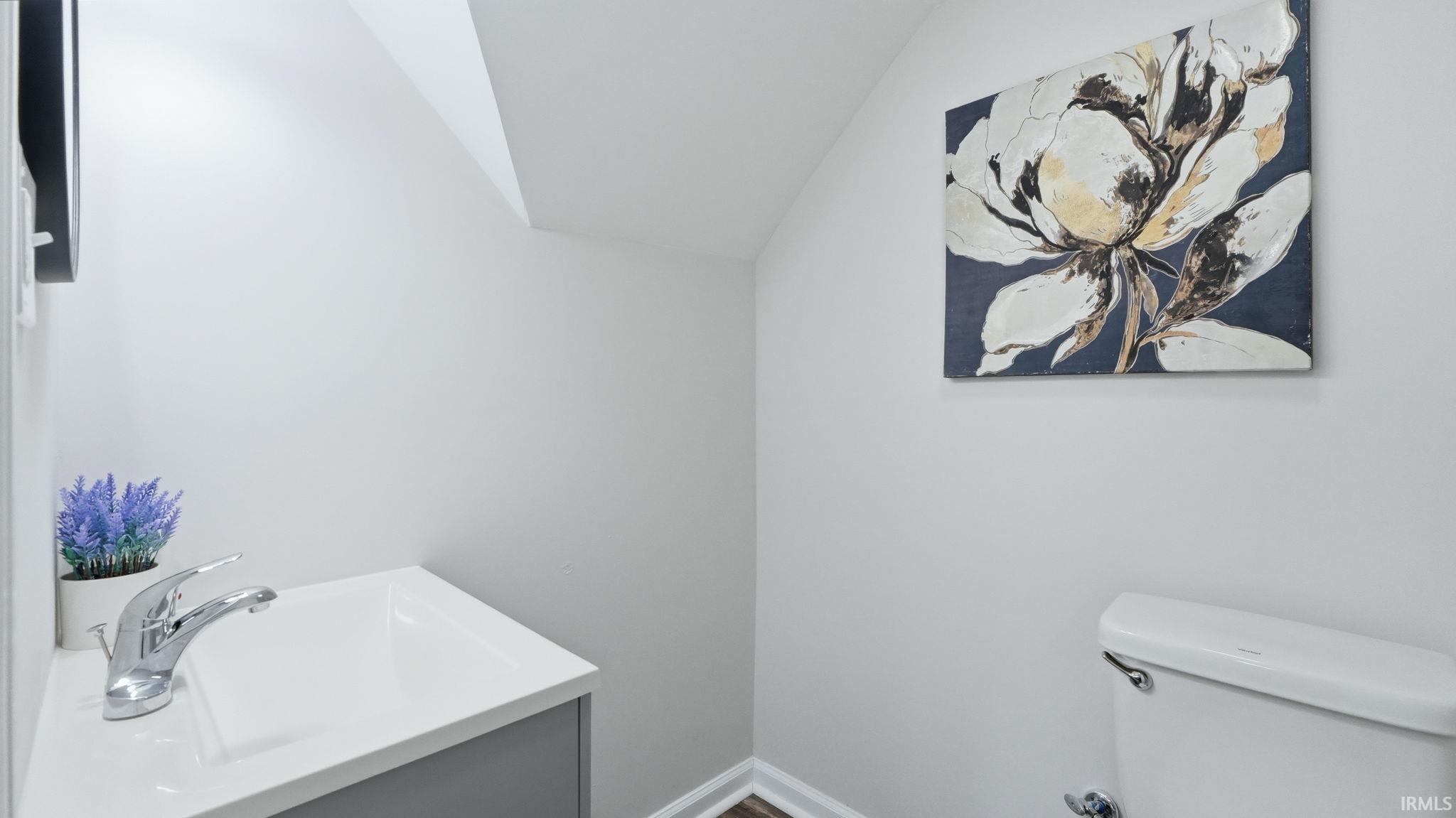 Recessed vanity with integrated white sink and chrome faucet, complemented by wood-finish flooring and light gray walls