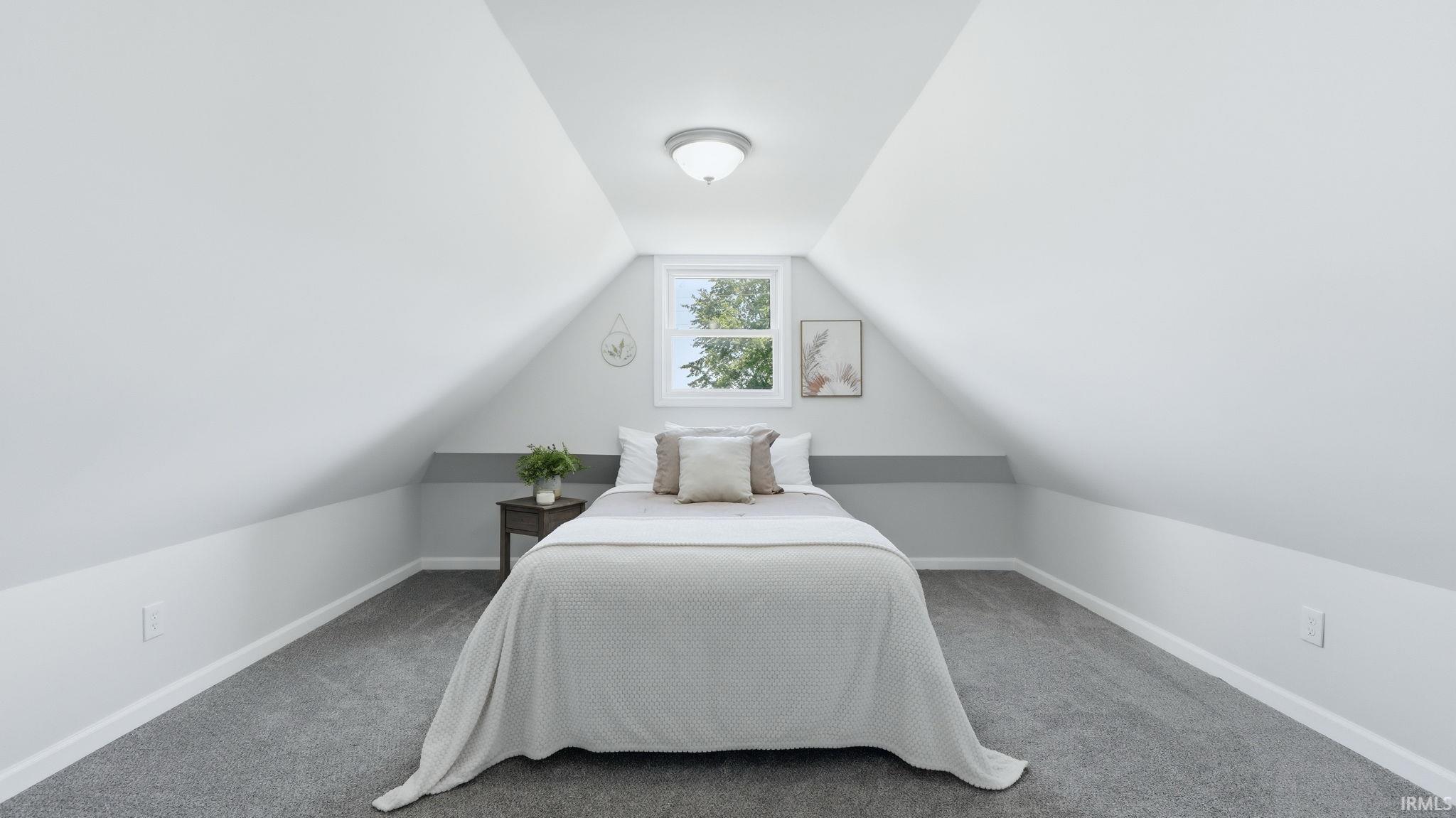 Attic bedroom featuring gray carpeting, a single window, white walls, and a semi-flush mount ceiling light