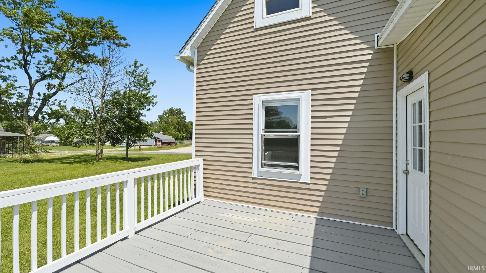 Exterior deck with grey wood-finish flooring and white railings