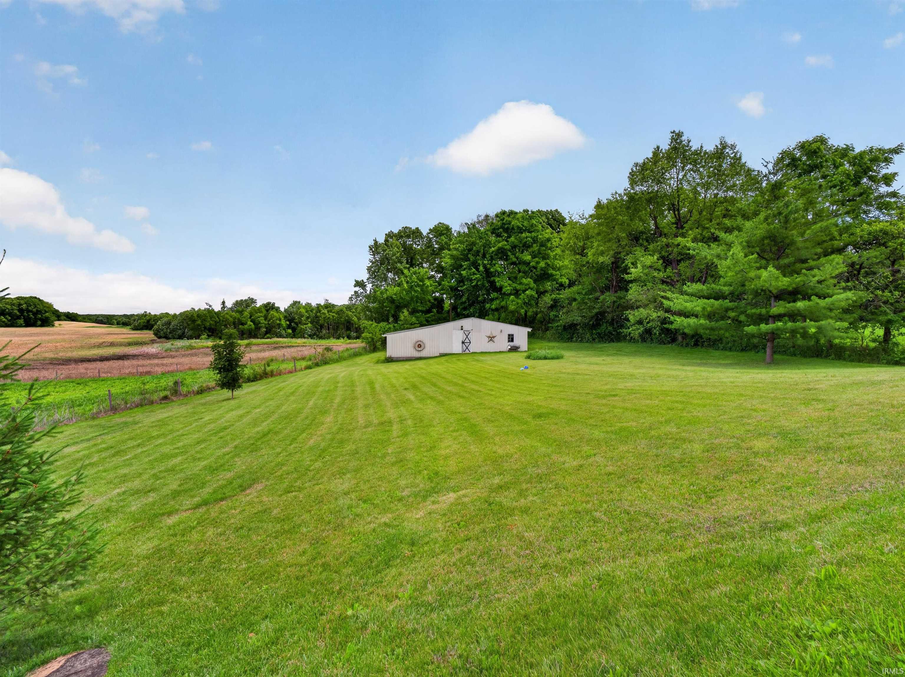 Expansive green lawn with a white outbuilding
