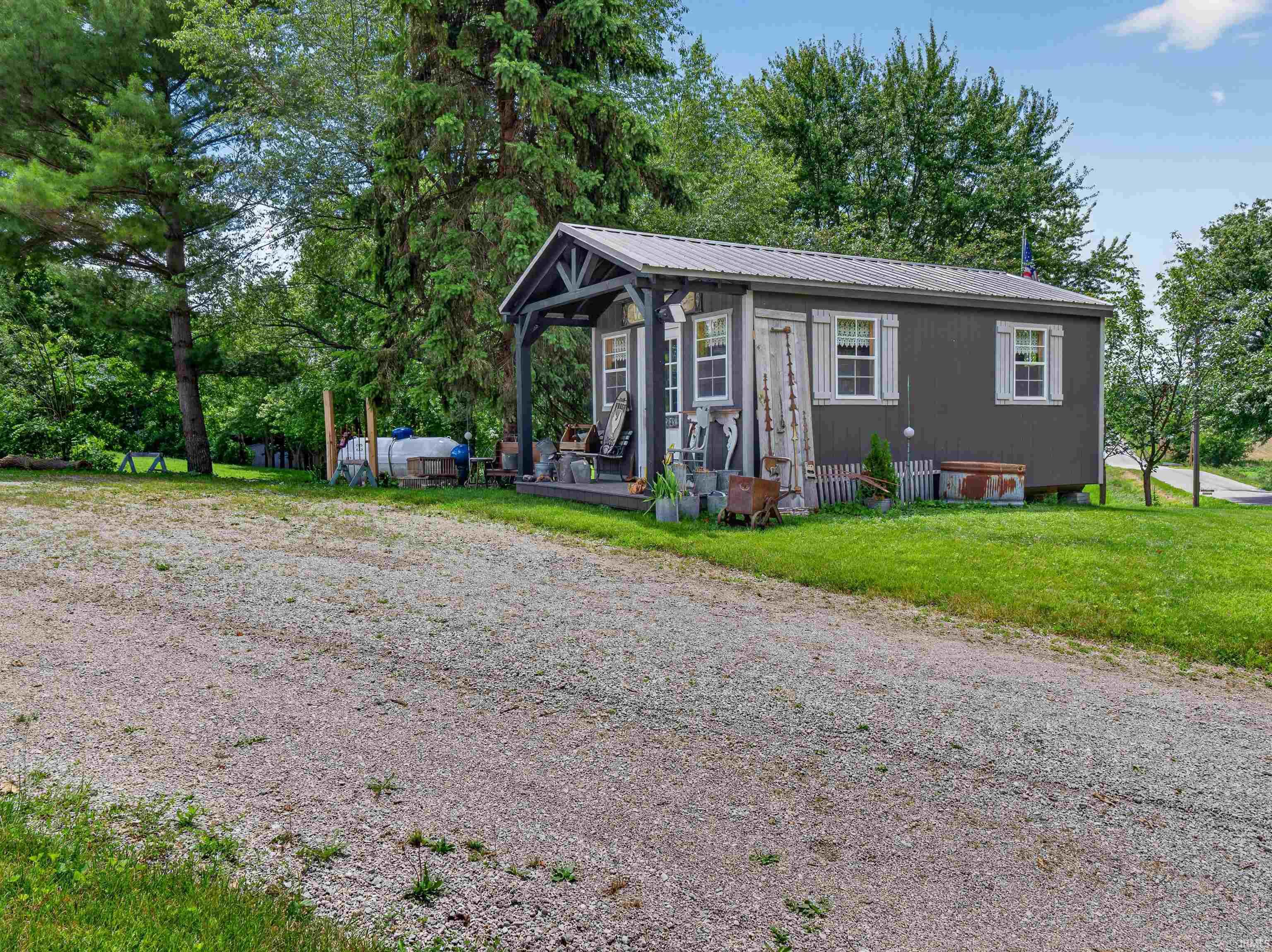 Compact structure featuring a covered front porch with exposed rafters and posts