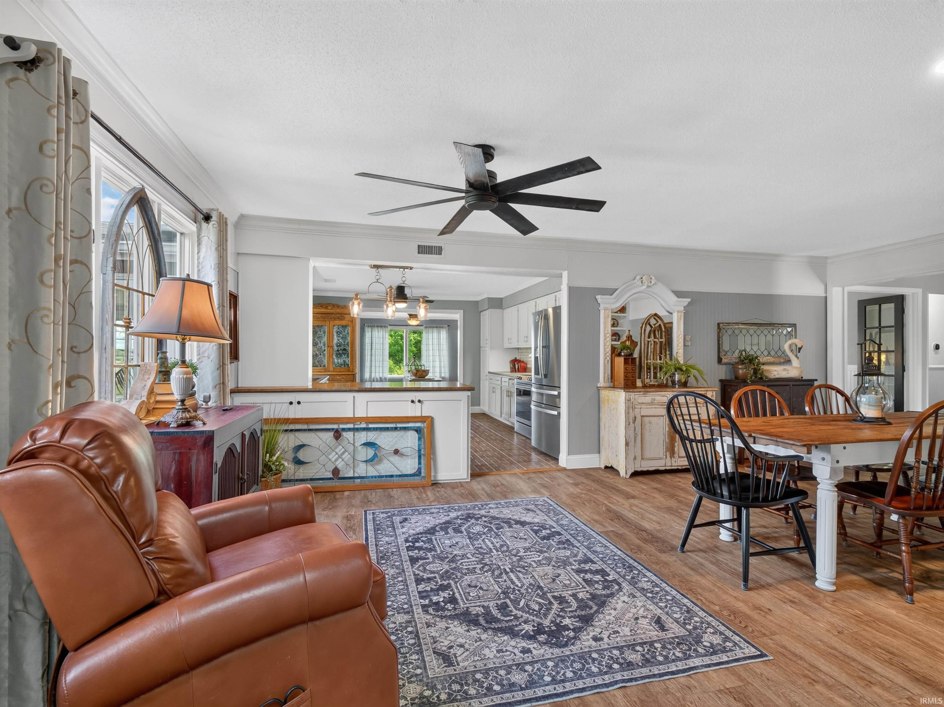 Open-concept living space featuring wood-finish flooring, a contemporary ceiling fan, and recessed lighting