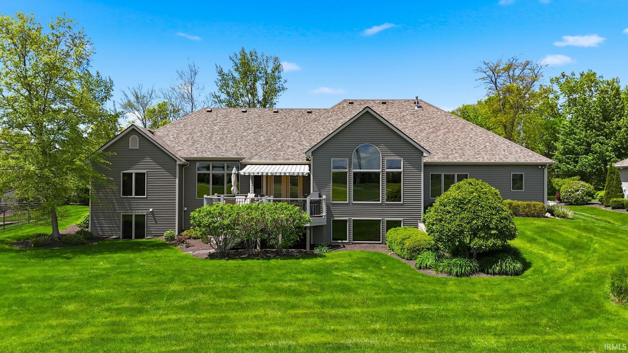 Expansive rear facade featuring multiple windows, a second-story deck, and a walk-out lower level