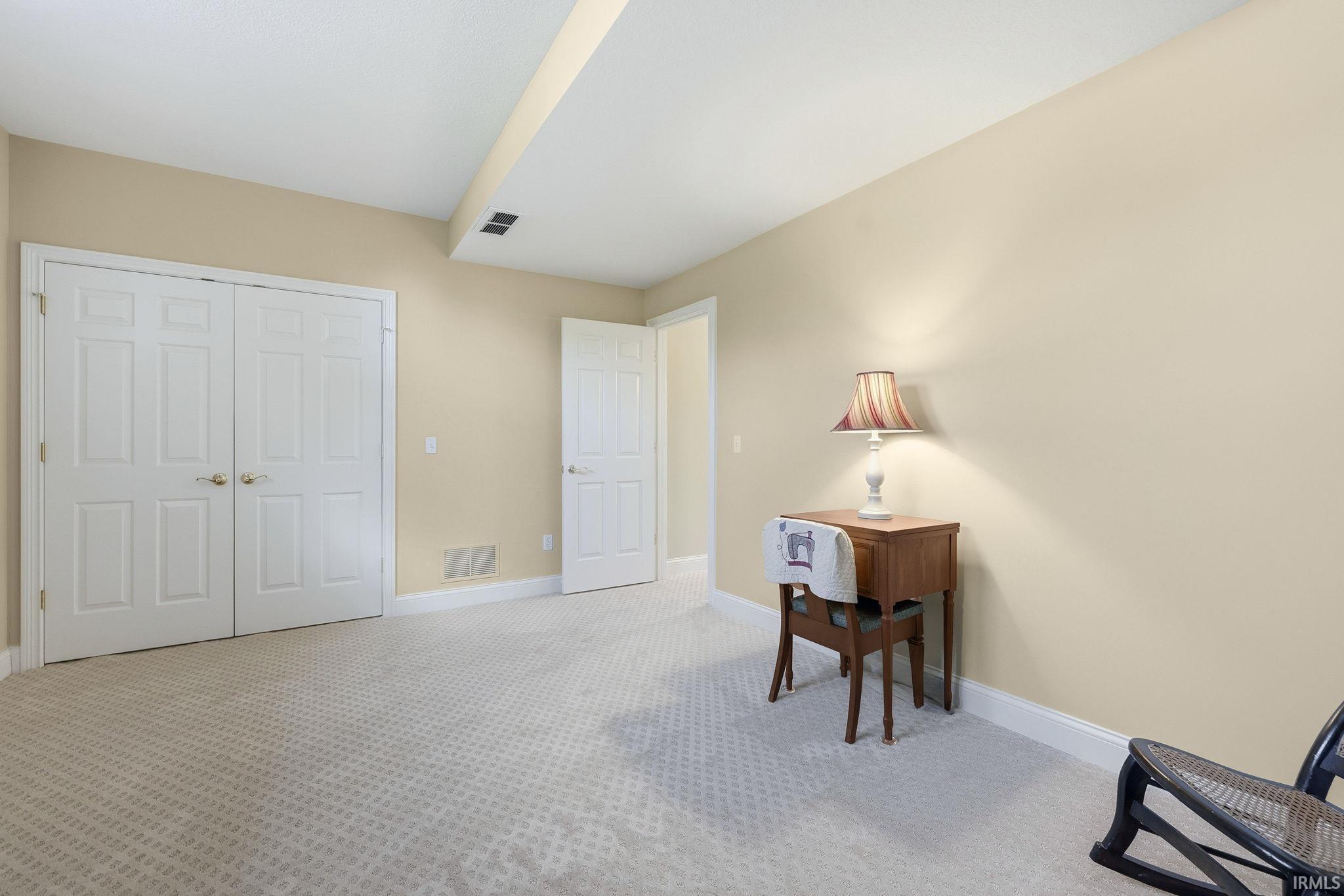 Neutral-toned walls complement the light-colored patterned carpet
