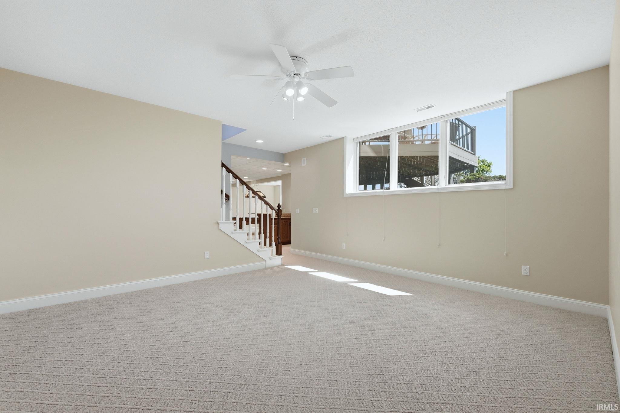 Spacious room featuring patterned carpeting and light beige wall tones