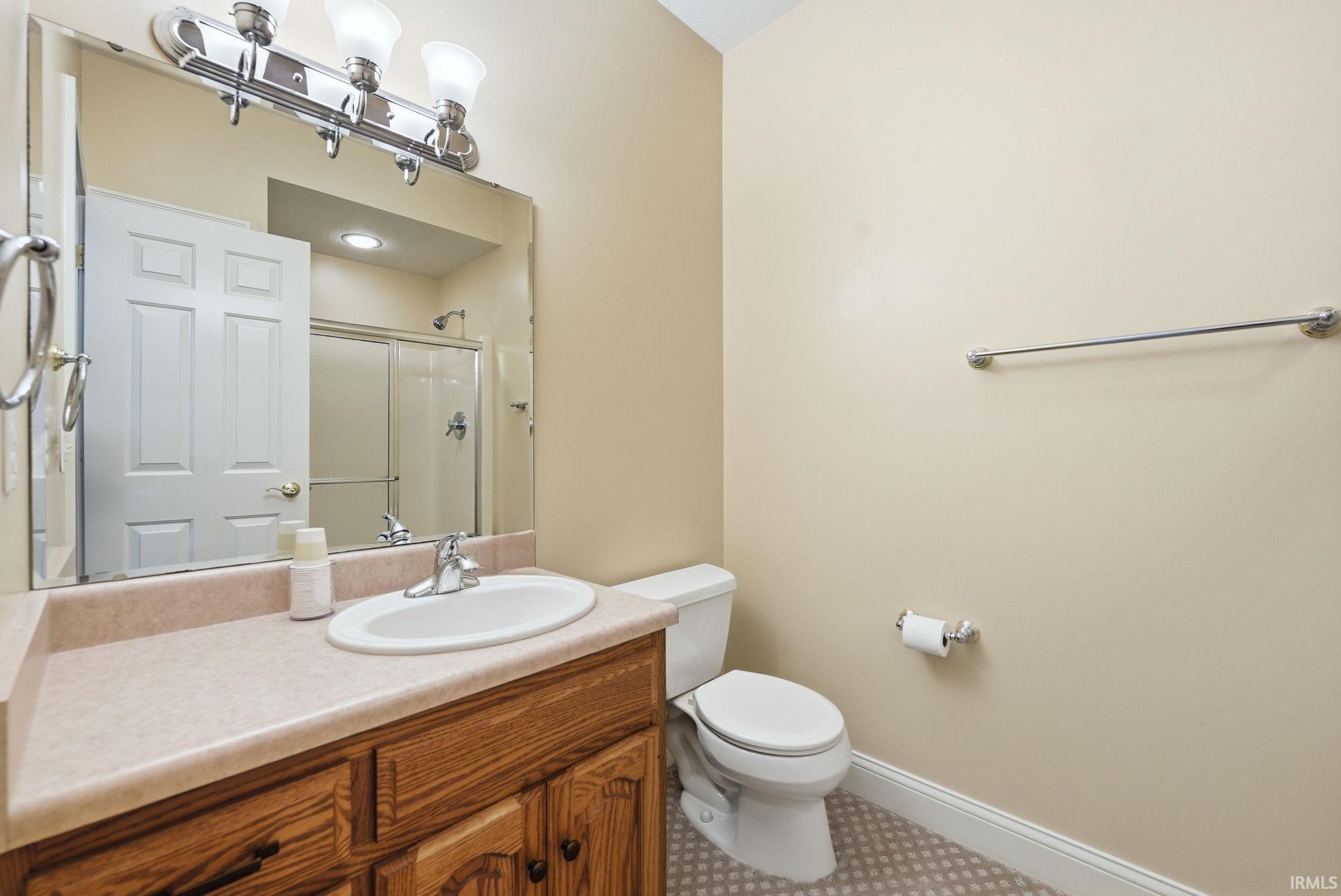Bathroom with wood-finish vanity, integrated sink, and light-toned countertop